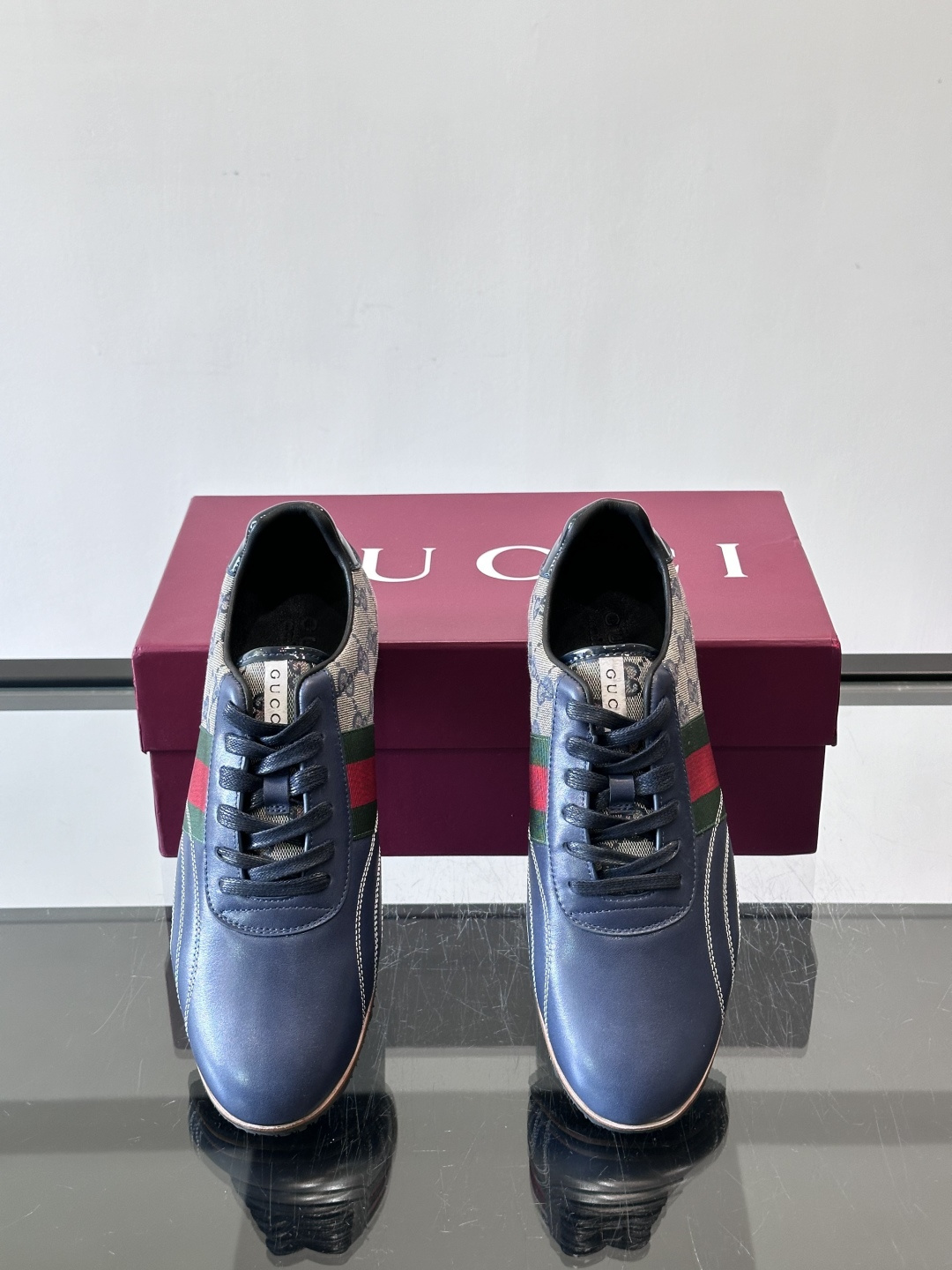 Gucci经典的复古运动鞋，采用皮革与GG老花帆布拼接设计，侧面饰有品牌标志性的红绿织带，鞋型圆润复古，