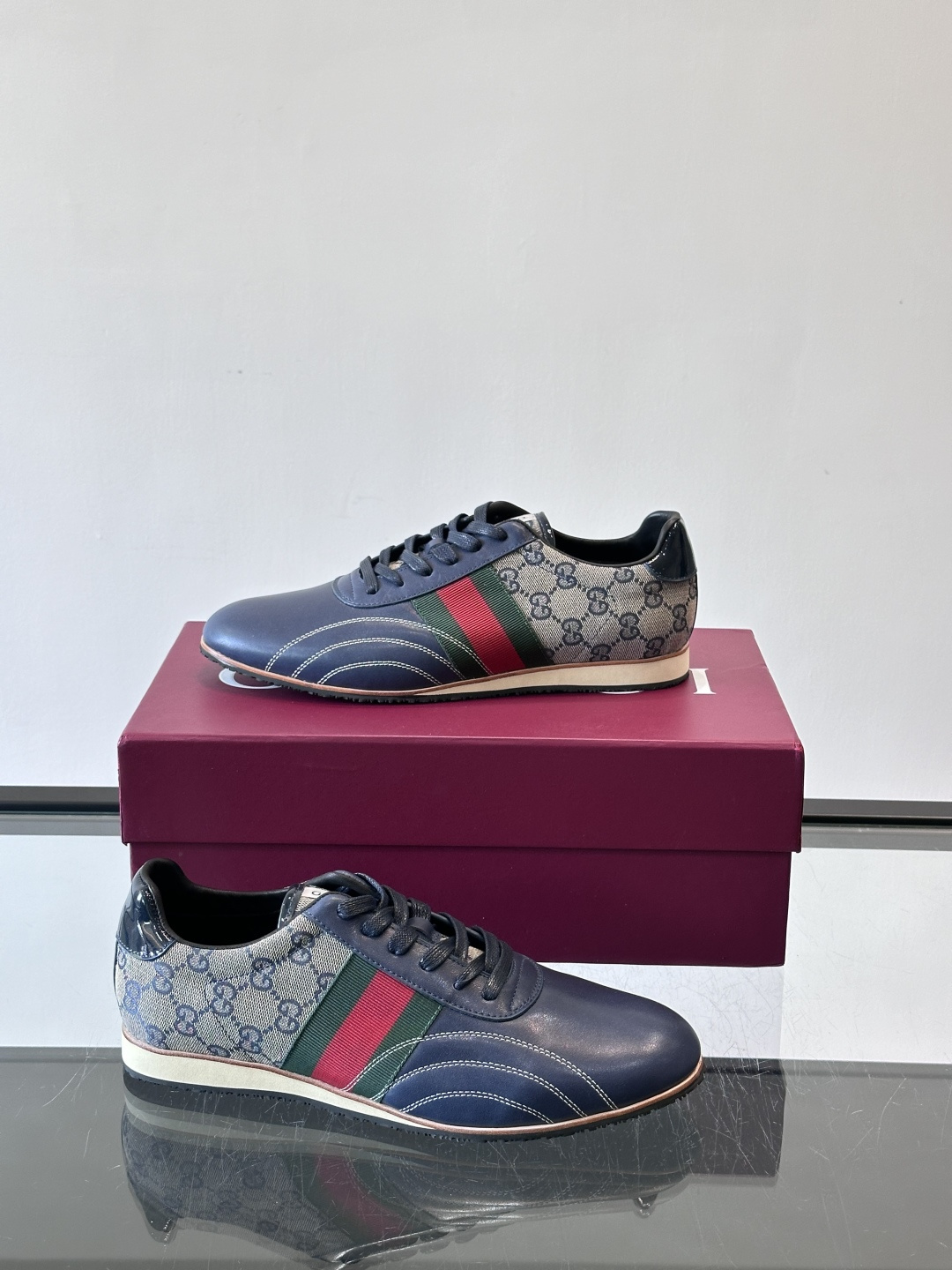 Gucci经典的复古运动鞋，采用皮革与GG老花帆布拼接设计，侧面饰有品牌标志性的红绿织带，鞋型圆润复古，