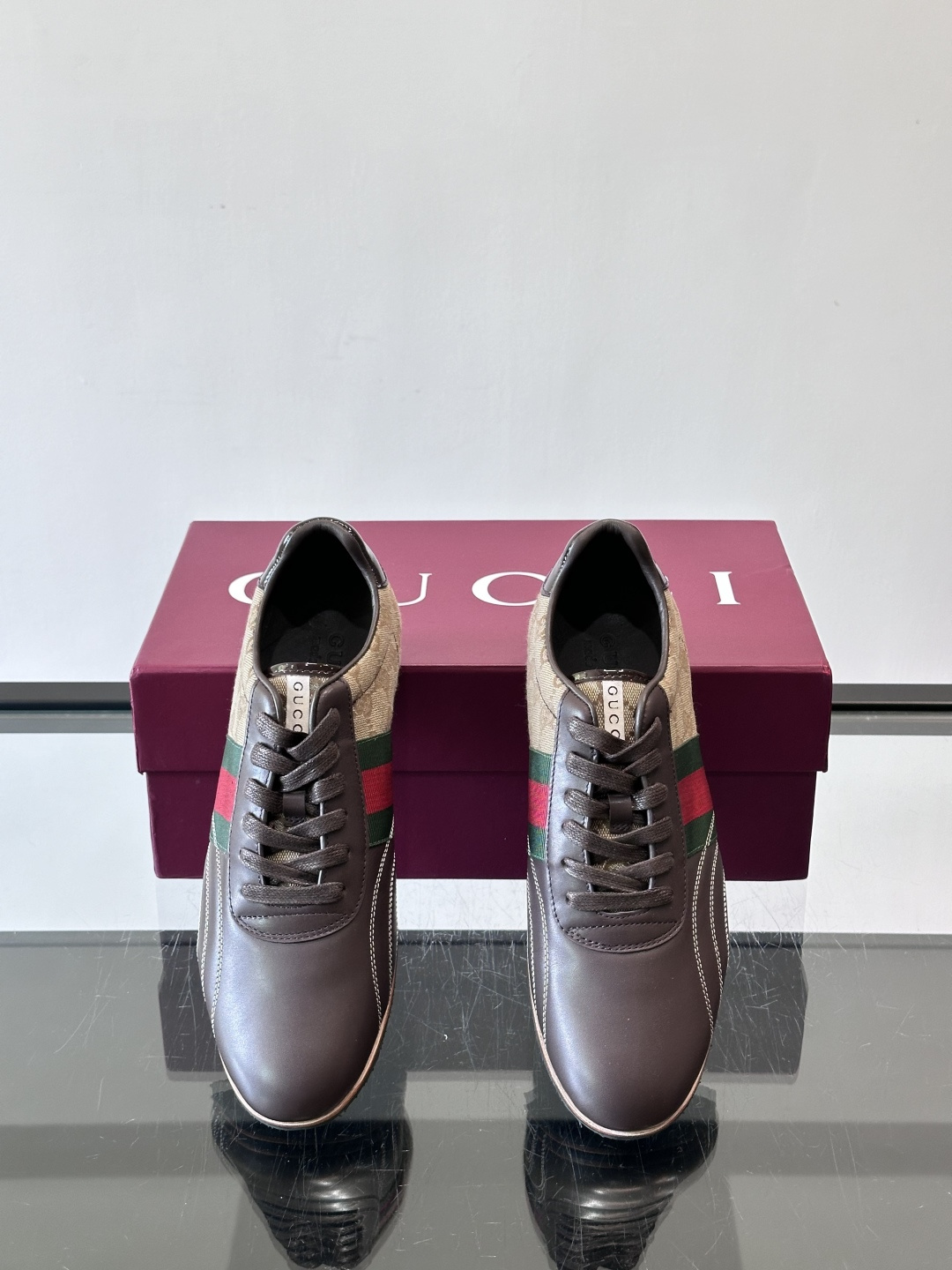 Gucci经典的复古运动鞋，采用皮革与GG老花帆布拼接设计，侧面饰有品牌标志性的红绿织带，鞋型圆润复古，