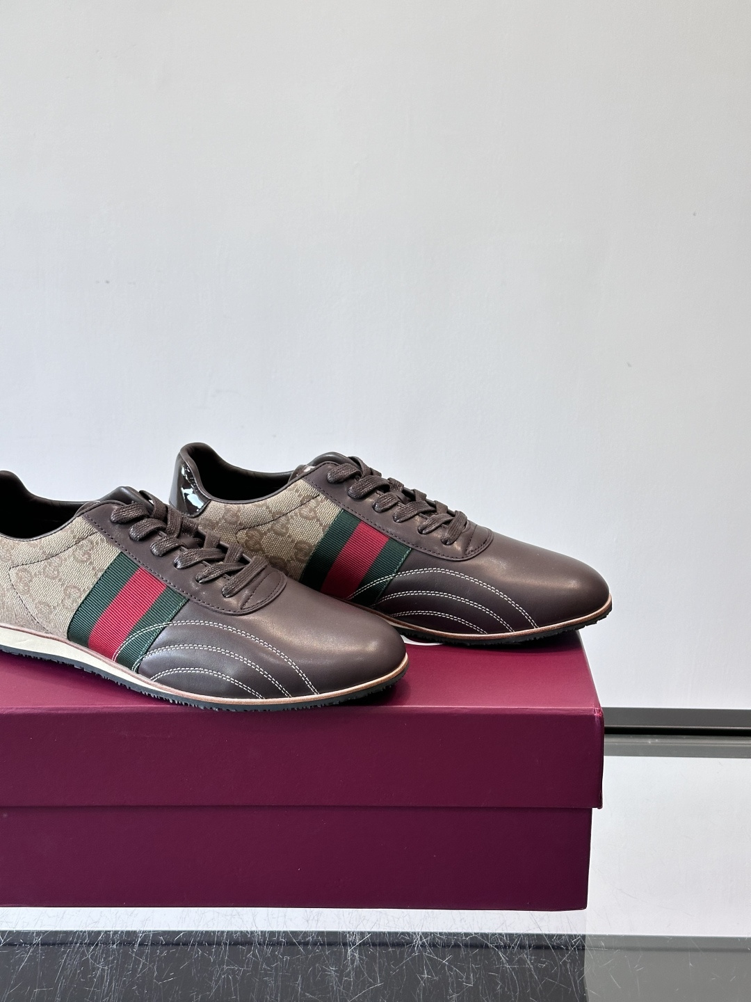 Gucci经典的复古运动鞋，采用皮革与GG老花帆布拼接设计，侧面饰有品牌标志性的红绿织带，鞋型圆润复古，