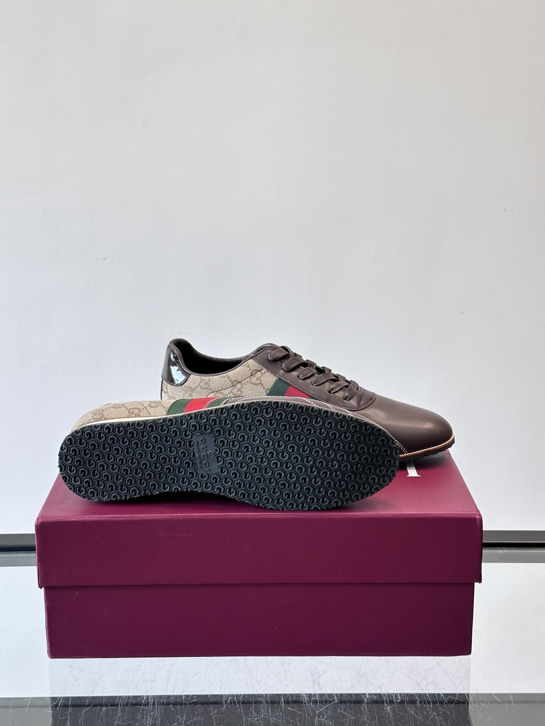 Gucci经典的复古运动鞋，采用皮革与GG老花帆布拼接设计，侧面饰有品牌标志性的红绿织带，鞋型圆润复古，