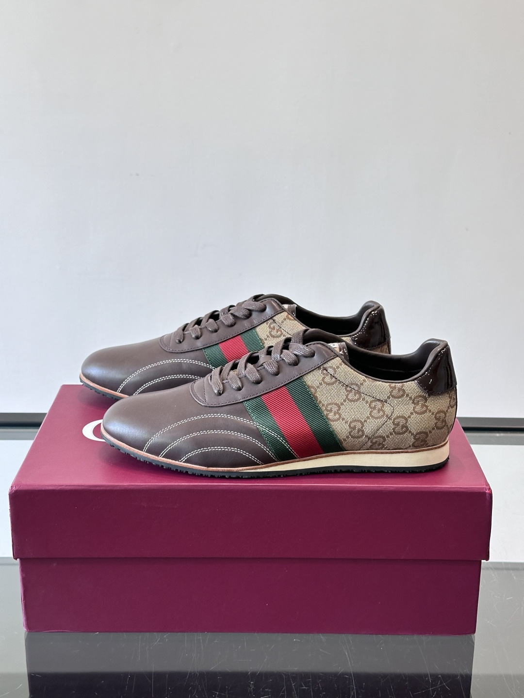 Gucci经典的复古运动鞋，采用皮革与GG老花帆布拼接设计，侧面饰有品牌标志性的红绿织带，鞋型圆润复古，