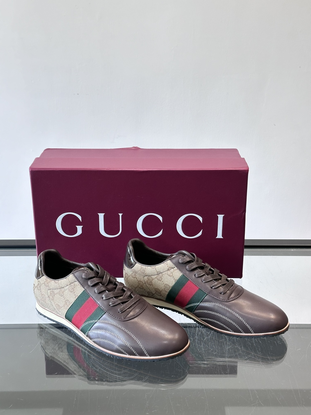 Gucci经典的复古运动鞋，采用皮革与GG老花帆布拼接设计，侧面饰有品牌标志性的红绿织带，鞋型圆润复古，