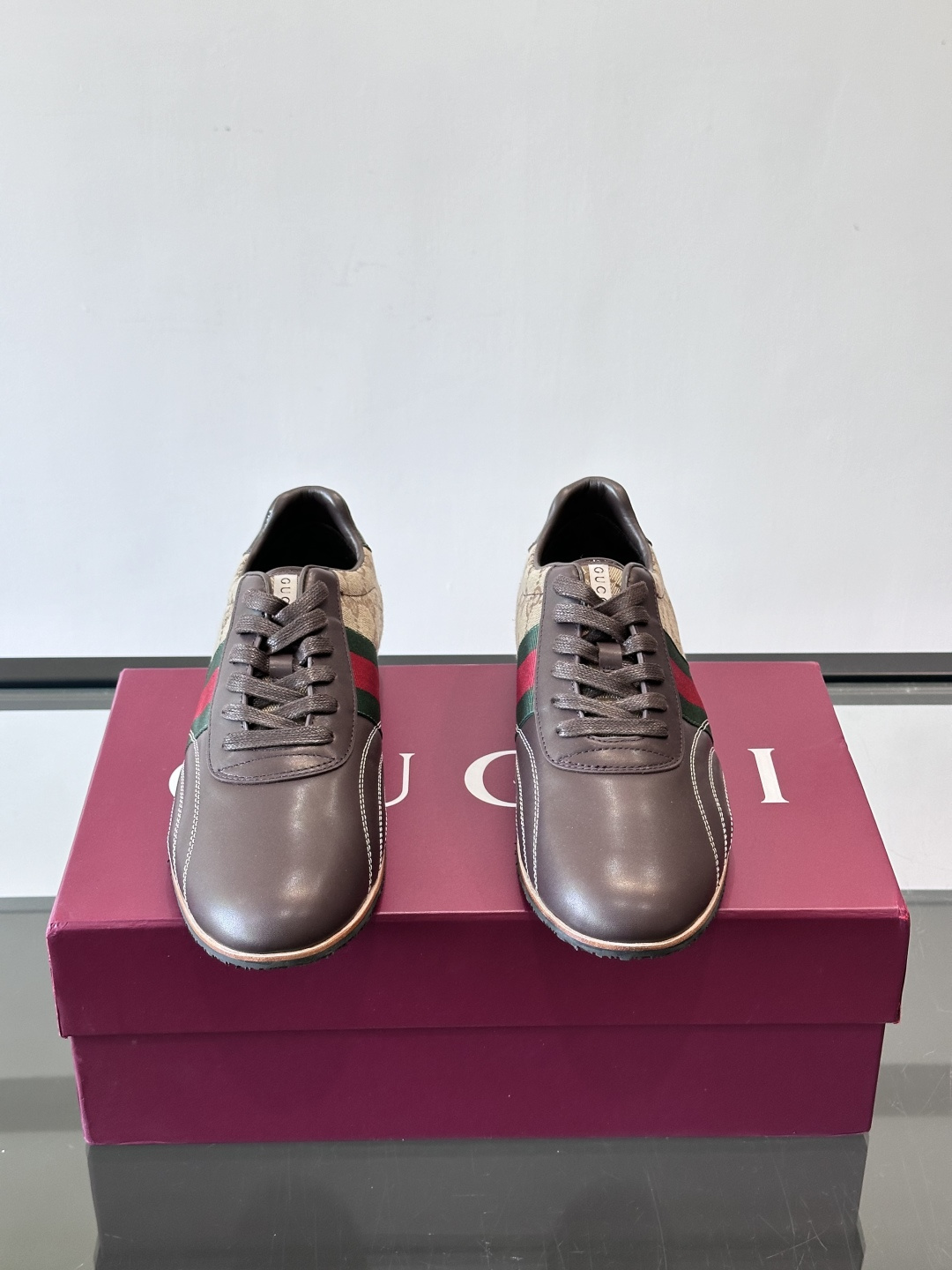 Gucci经典的复古运动鞋，采用皮革与GG老花帆布拼接设计，侧面饰有品牌标志性的红绿织带，鞋型圆润复古，