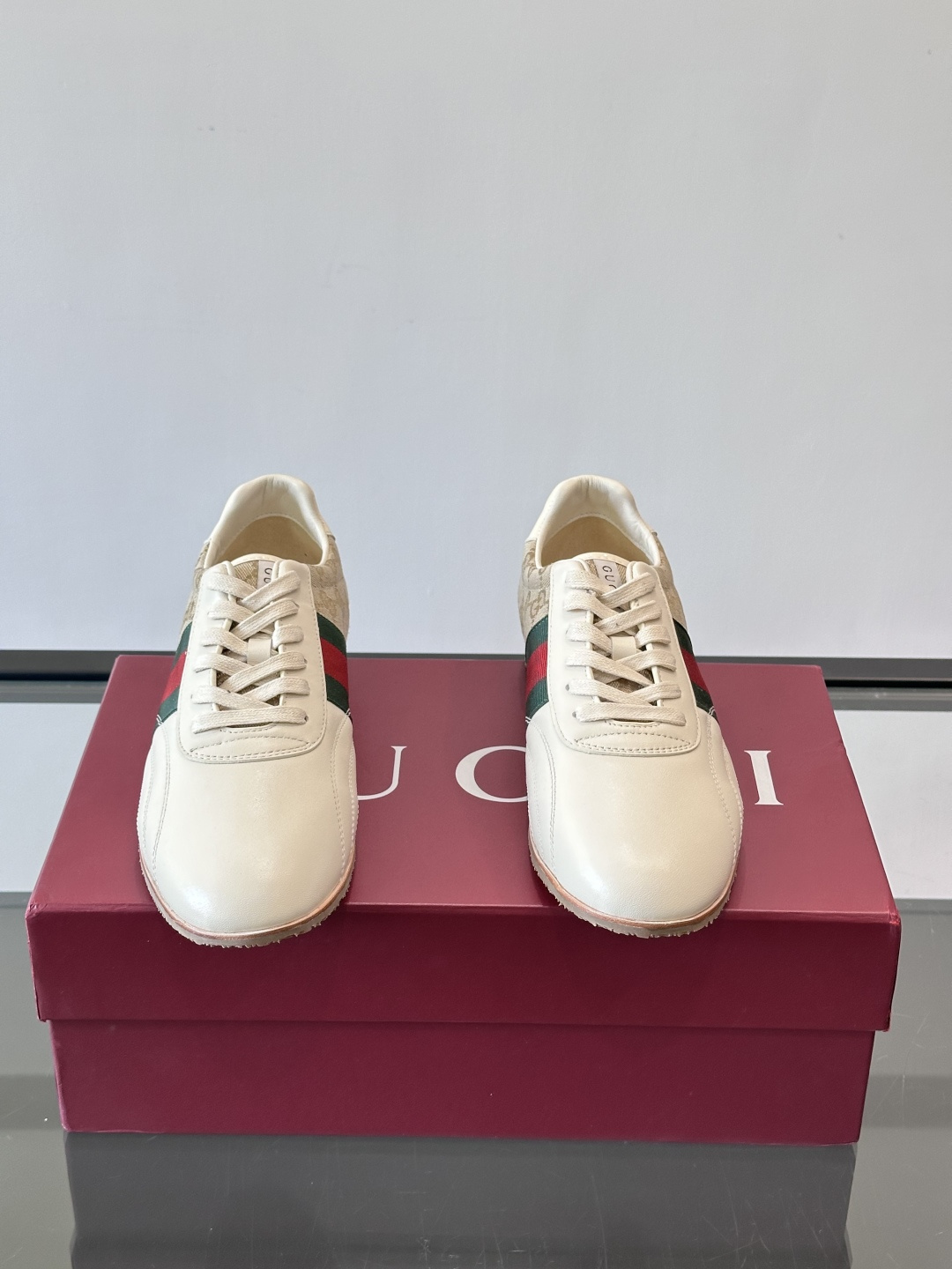 Gucci经典的复古运动鞋，采用皮革与GG老花帆布拼接设计，侧面饰有品牌标志性的红绿织带，鞋型圆润复古，