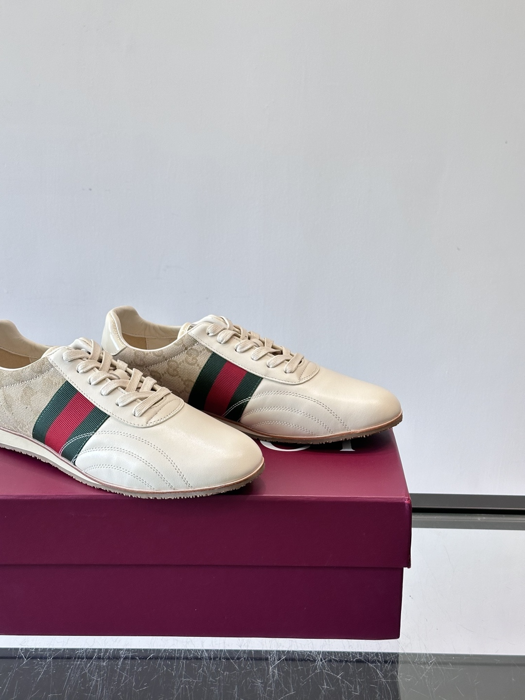 Gucci经典的复古运动鞋，采用皮革与GG老花帆布拼接设计，侧面饰有品牌标志性的红绿织带，鞋型圆润复古，