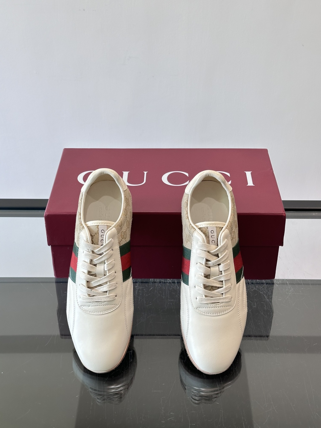 Gucci经典的复古运动鞋，采用皮革与GG老花帆布拼接设计，侧面饰有品牌标志性的红绿织带，鞋型圆润复古，