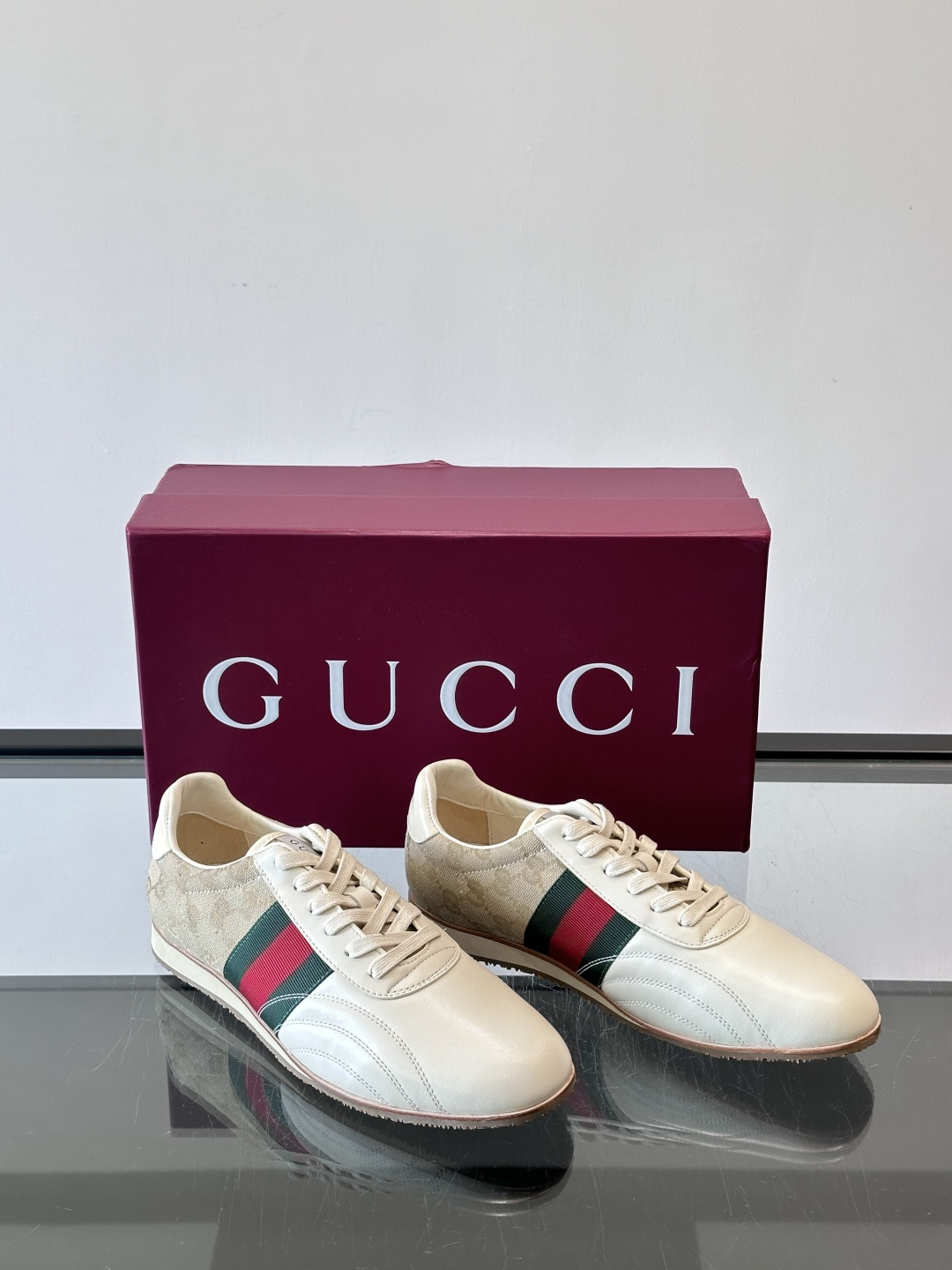 Gucci经典的复古运动鞋，采用皮革与GG老花帆布拼接设计，侧面饰有品牌标志性的红绿织带，鞋型圆润复古，