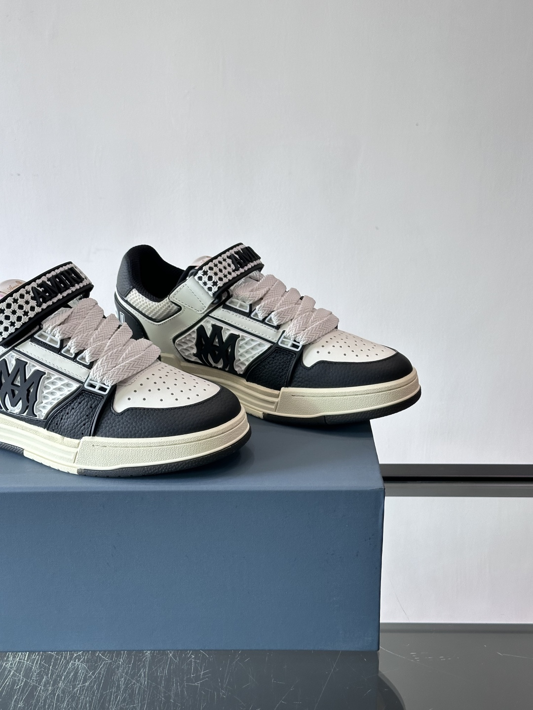 AMIRI拼色运动鞋​，这双AMIRI拼色运动鞋是品牌标志性的复古街头风格代表，采用经典黑白撞色设计，搭