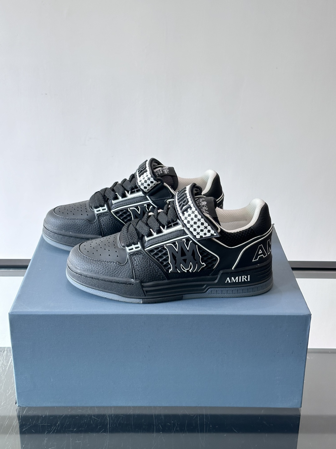 AMIRI拼色运动鞋​，这双AMIRI拼色运动鞋是品牌标志性的复古街头风格代表，采用经典黑白撞色设计，搭