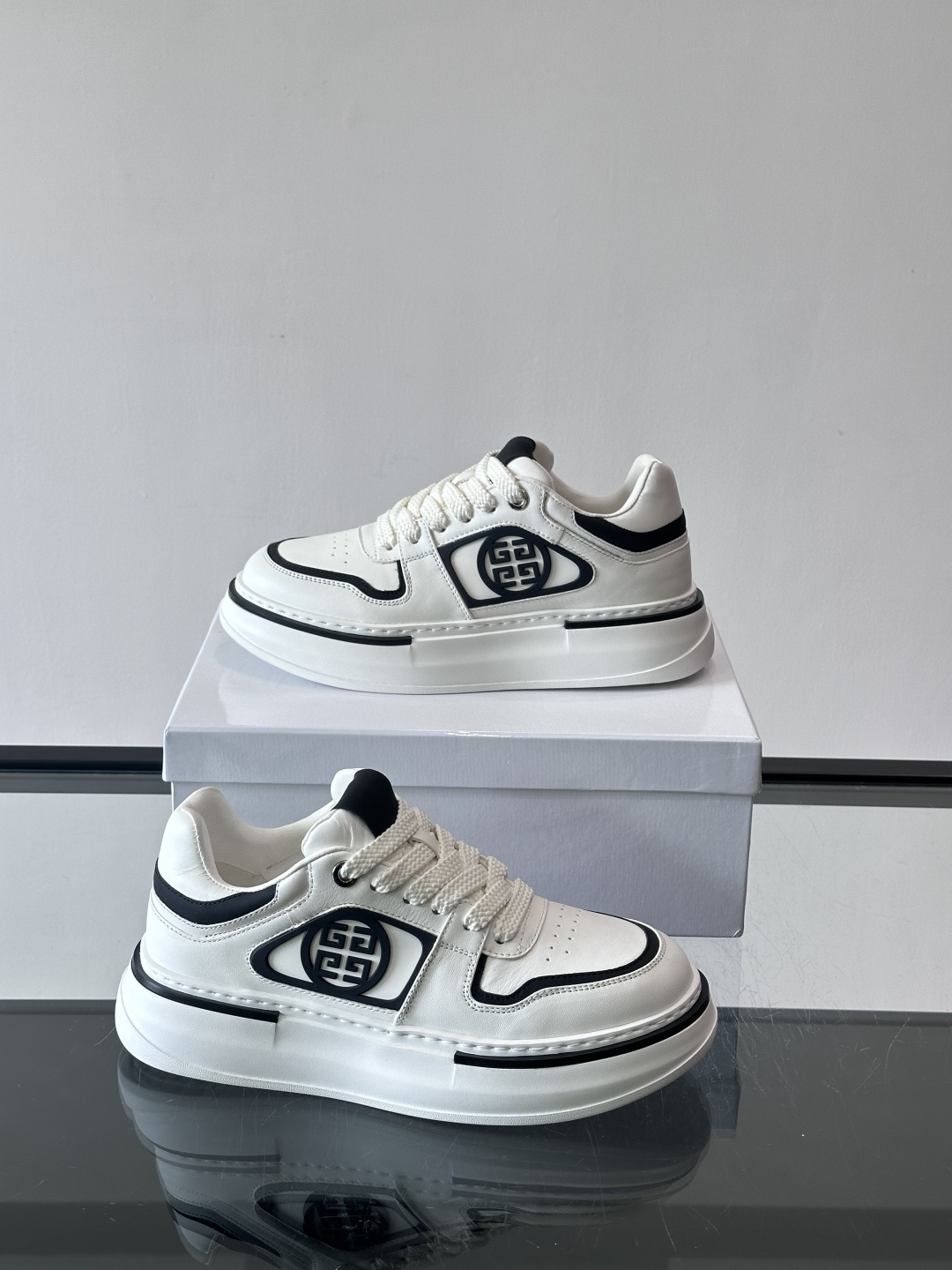 纪梵希GIVENCHY经典的厚底运动鞋，鞋身以纯净白色为主调，搭配黑色线条勾勒轮廓，鞋侧标志性“4G”金