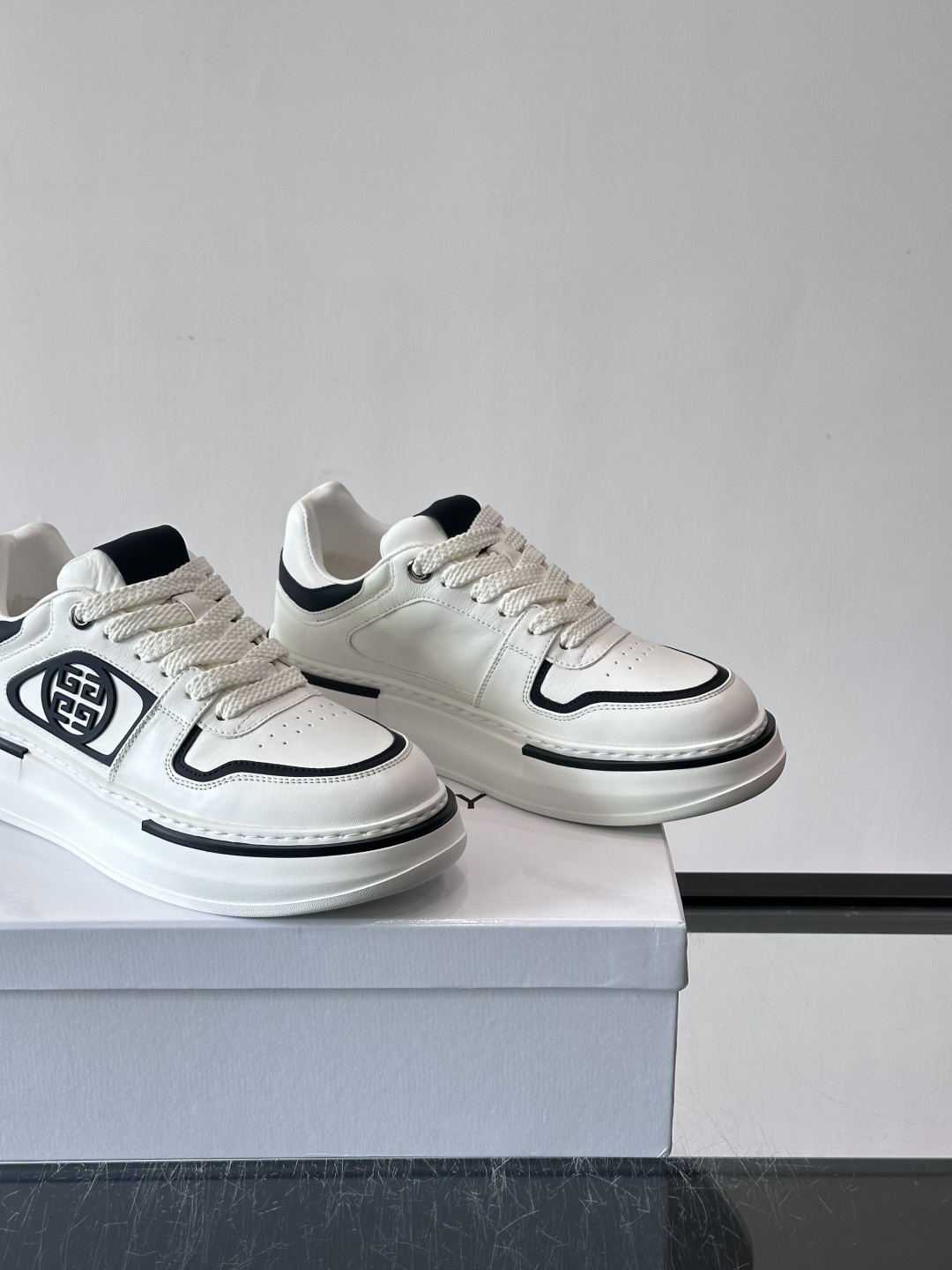 纪梵希GIVENCHY经典的厚底运动鞋，鞋身以纯净白色为主调，搭配黑色线条勾勒轮廓，鞋侧标志性“4G”金