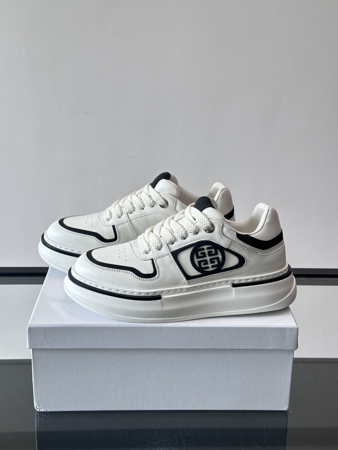 纪梵希GIVENCHY经典的厚底运动鞋，鞋身以纯净白色为主调，搭配黑色线条勾勒轮廓，鞋侧标志性“4G”金