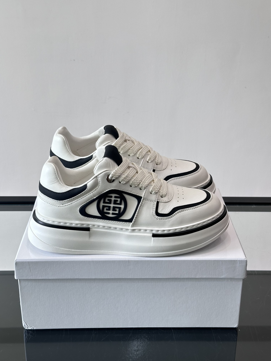 纪梵希GIVENCHY经典的厚底运动鞋，鞋身以纯净白色为主调，搭配黑色线条勾勒轮廓，鞋侧标志性“4G”金