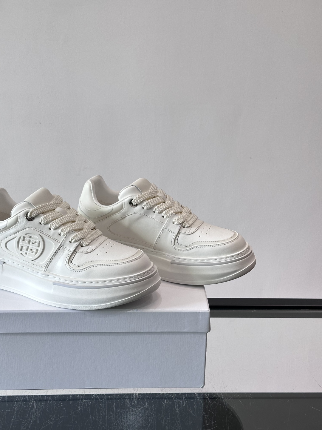 纪梵希GIVENCHY经典的厚底运动鞋，鞋身以纯净白色为主调，搭配黑色线条勾勒轮廓，鞋侧标志性“4G”金