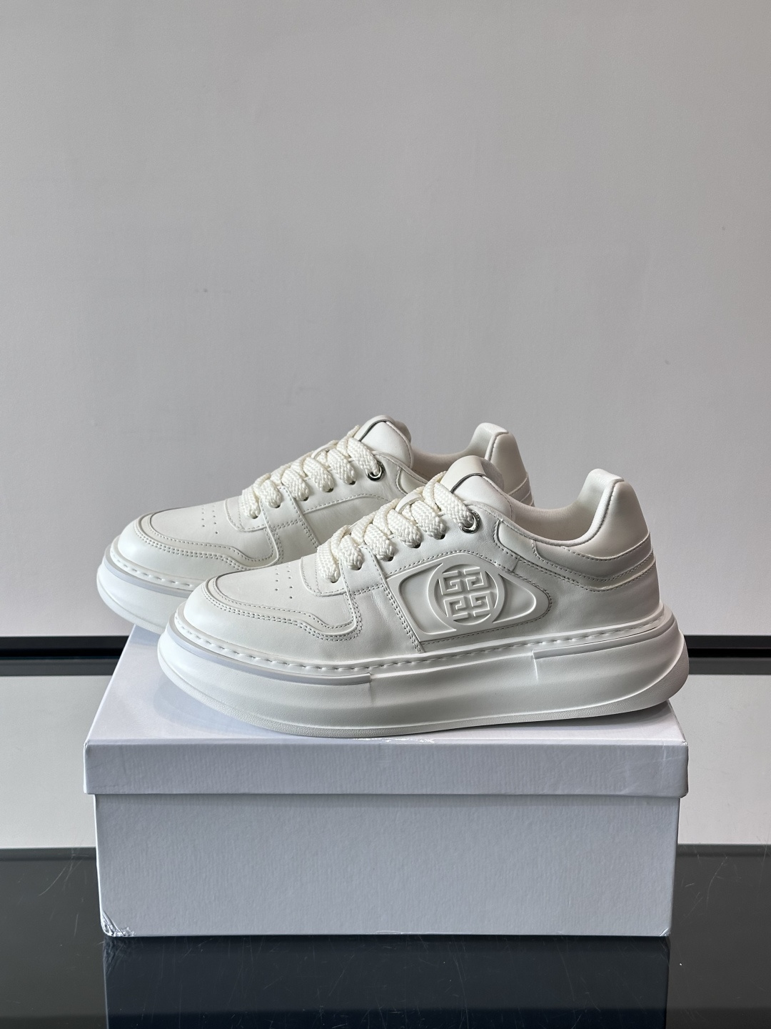 纪梵希GIVENCHY经典的厚底运动鞋，鞋身以纯净白色为主调，搭配黑色线条勾勒轮廓，鞋侧标志性“4G”金