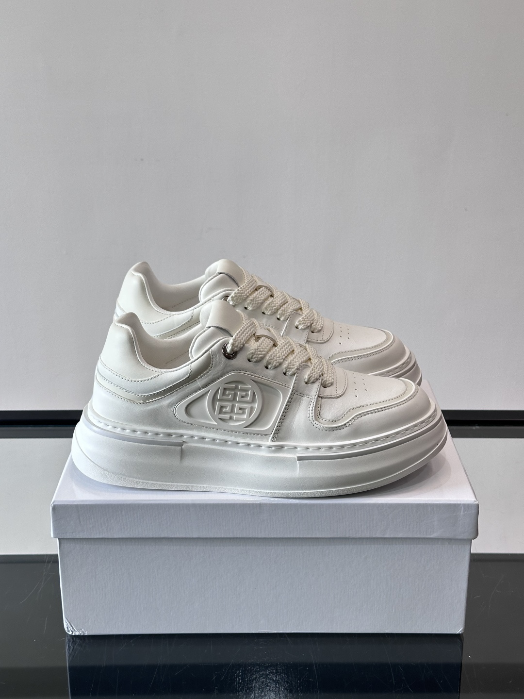 纪梵希GIVENCHY经典的厚底运动鞋，鞋身以纯净白色为主调，搭配黑色线条勾勒轮廓，鞋侧标志性“4G”金