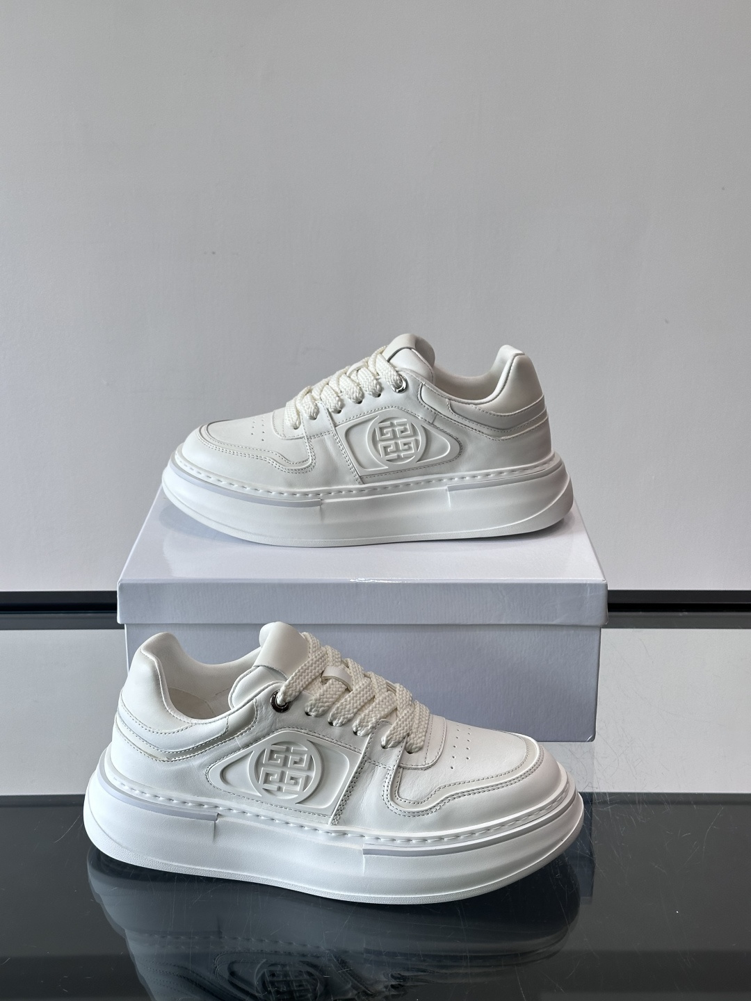 纪梵希GIVENCHY经典的厚底运动鞋，鞋身以纯净白色为主调，搭配黑色线条勾勒轮廓，鞋侧标志性“4G”金