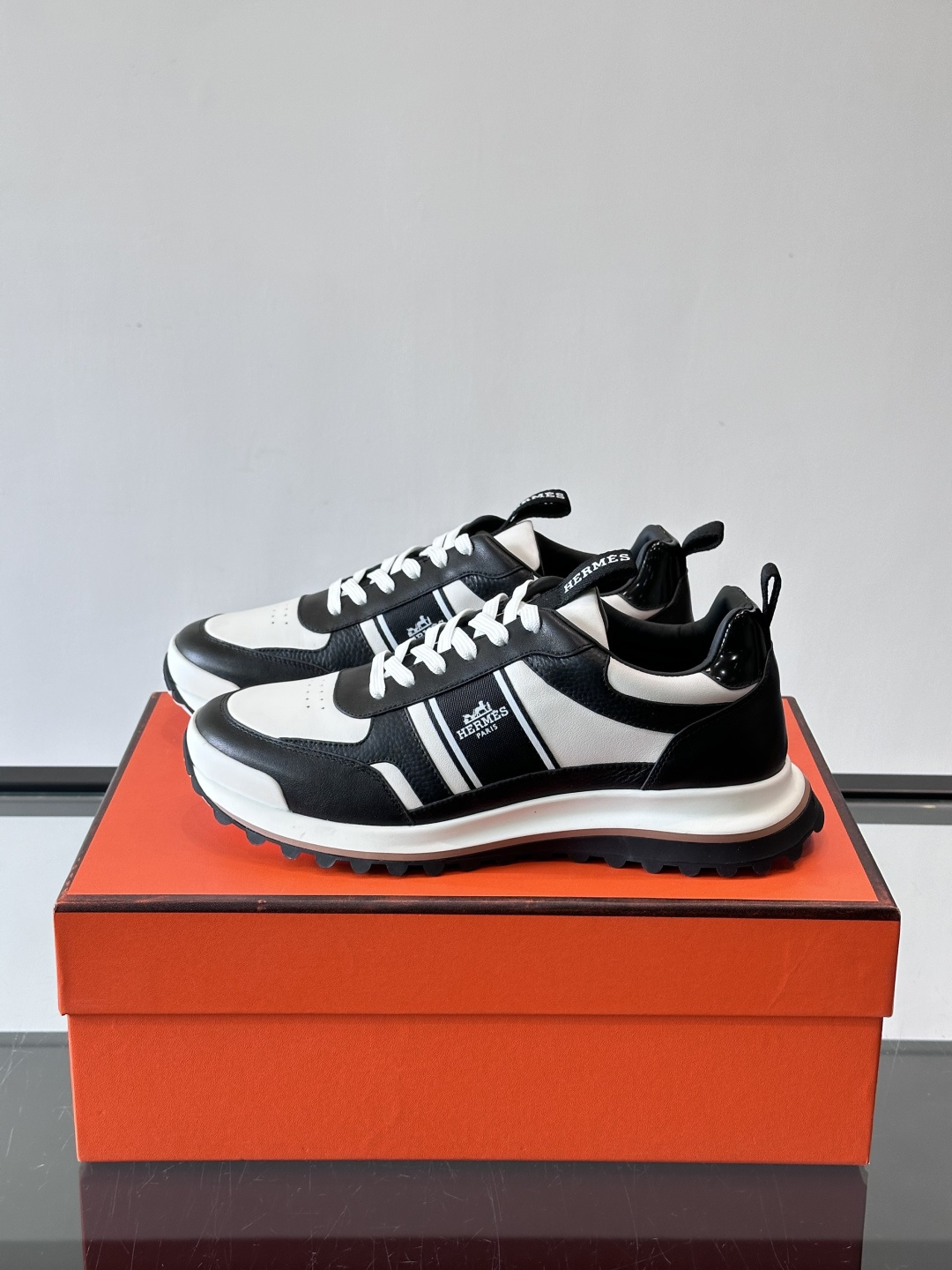 Hermes（爱马仕）的“Mystérieux”系列，鞋身采用优质皮革拼接设计，侧面黑色织带饰有品牌经典