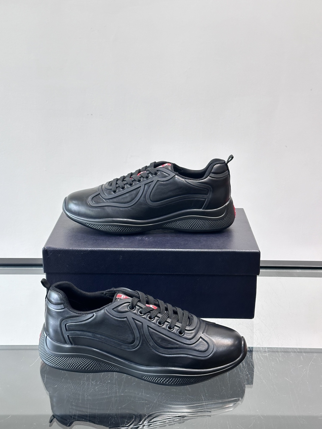 Prada经典漆皮厚底运动鞋，鞋面采用高光泽感的漆皮材质，搭配厚底和黑色鞋带，整体设计复古又时髦，带有强