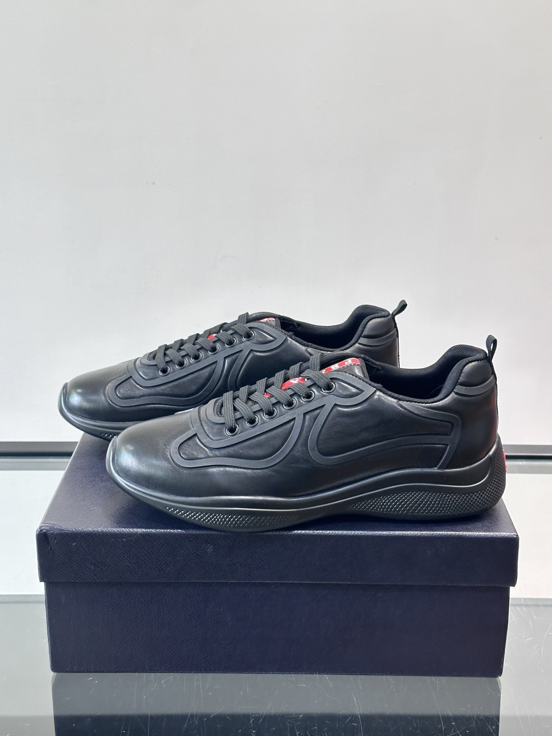 Prada经典漆皮厚底运动鞋，鞋面采用高光泽感的漆皮材质，搭配厚底和黑色鞋带，整体设计复古又时髦，带有强