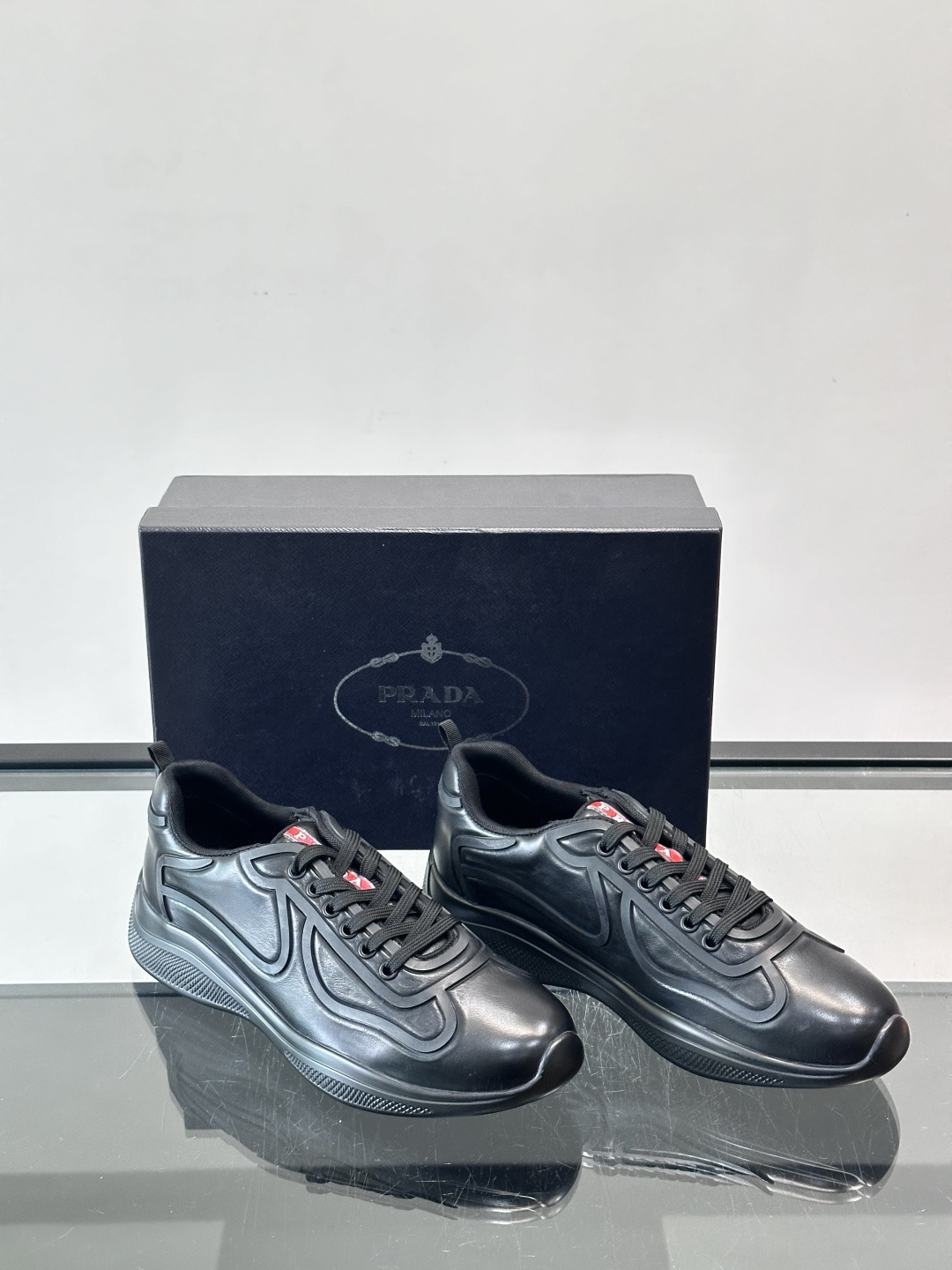 Prada经典漆皮厚底运动鞋，鞋面采用高光泽感的漆皮材质，搭配厚底和黑色鞋带，整体设计复古又时髦，带有强