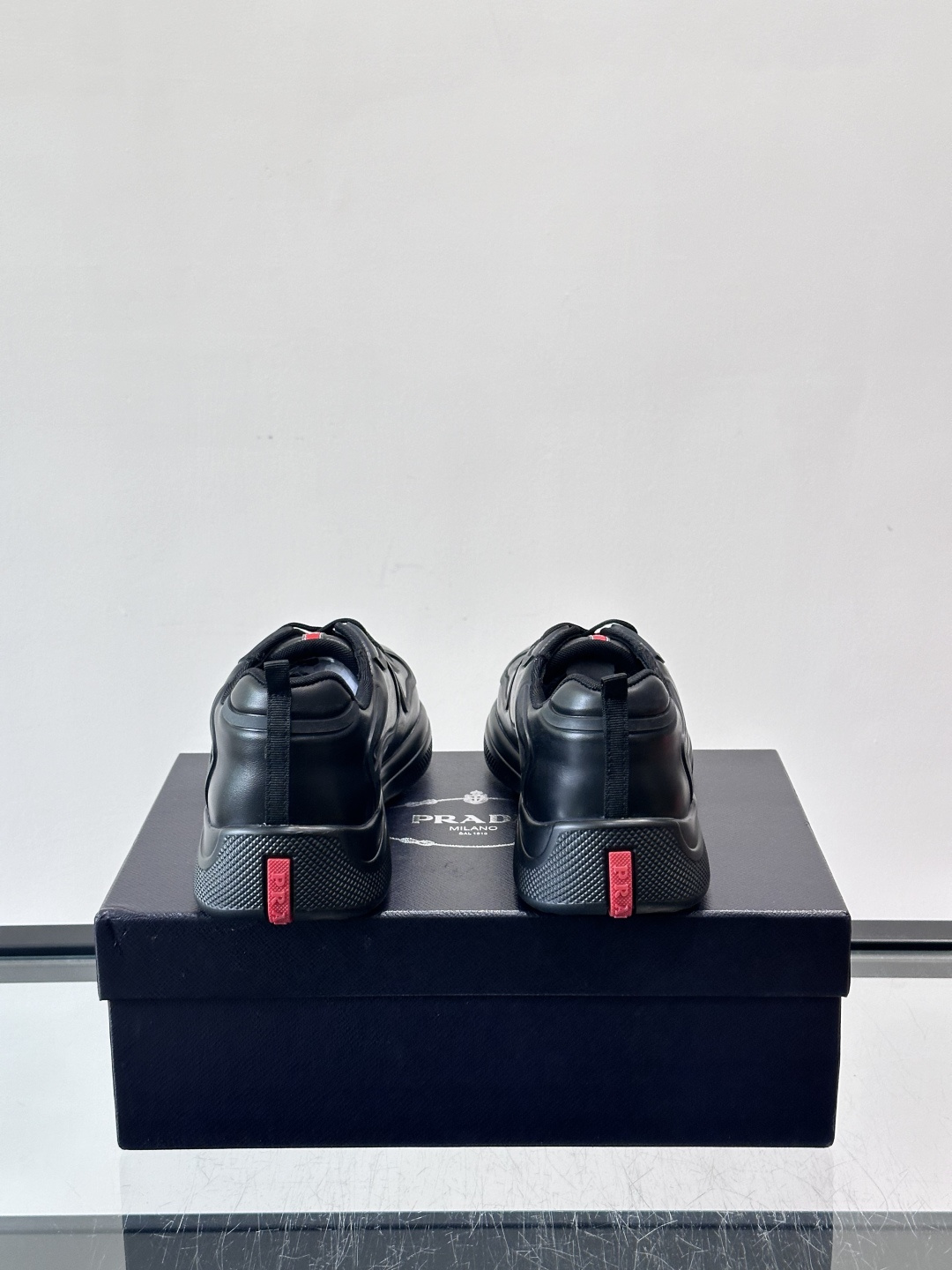 Prada经典漆皮厚底运动鞋，鞋面采用高光泽感的漆皮材质，搭配厚底和黑色鞋带，整体设计复古又时髦，带有强