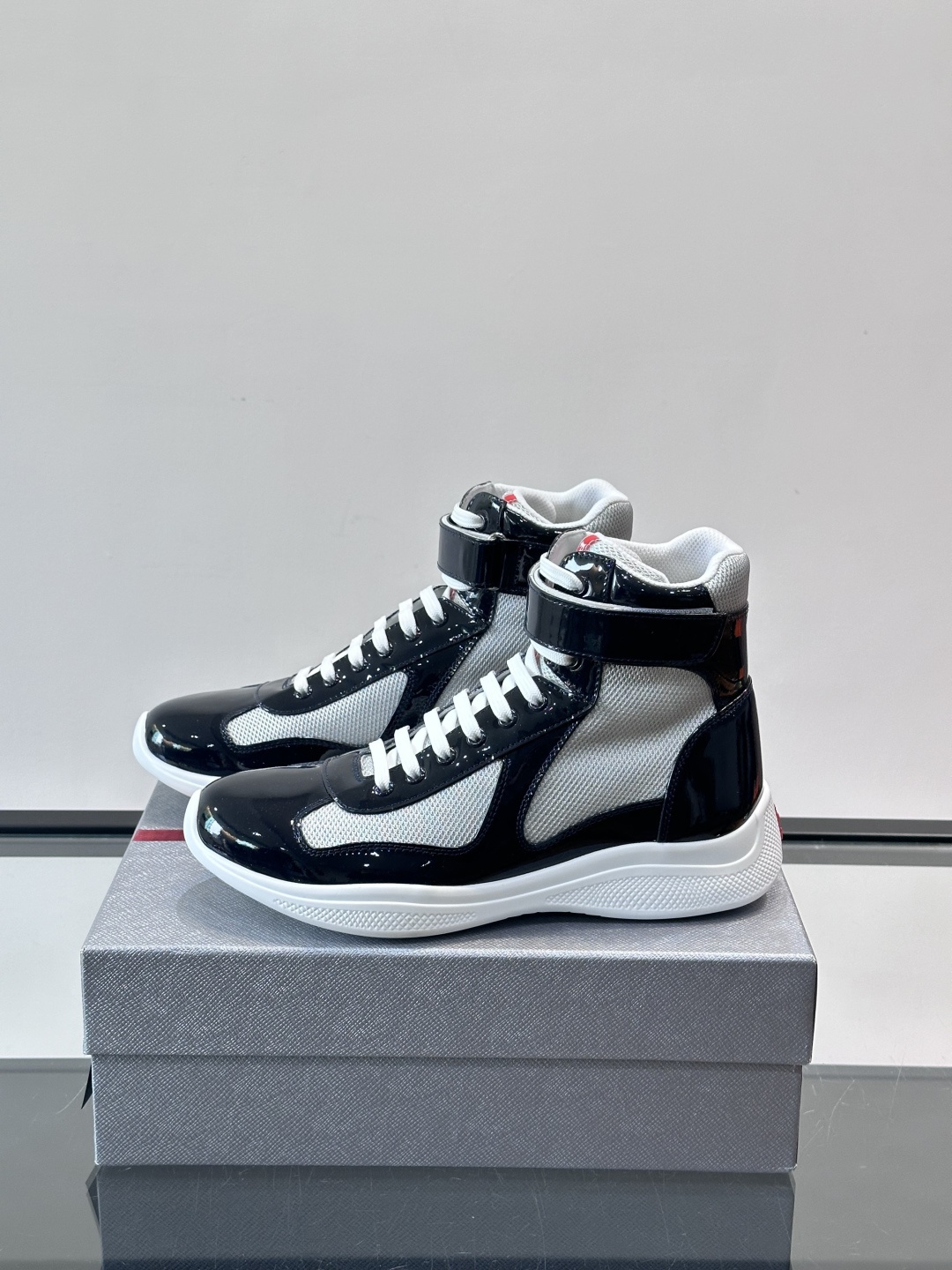 Prada 美洲杯高帮运动鞋​​✨Prada美洲杯系列运动鞋，漆皮+网面拼接，光泽感与透气性兼具。高帮设