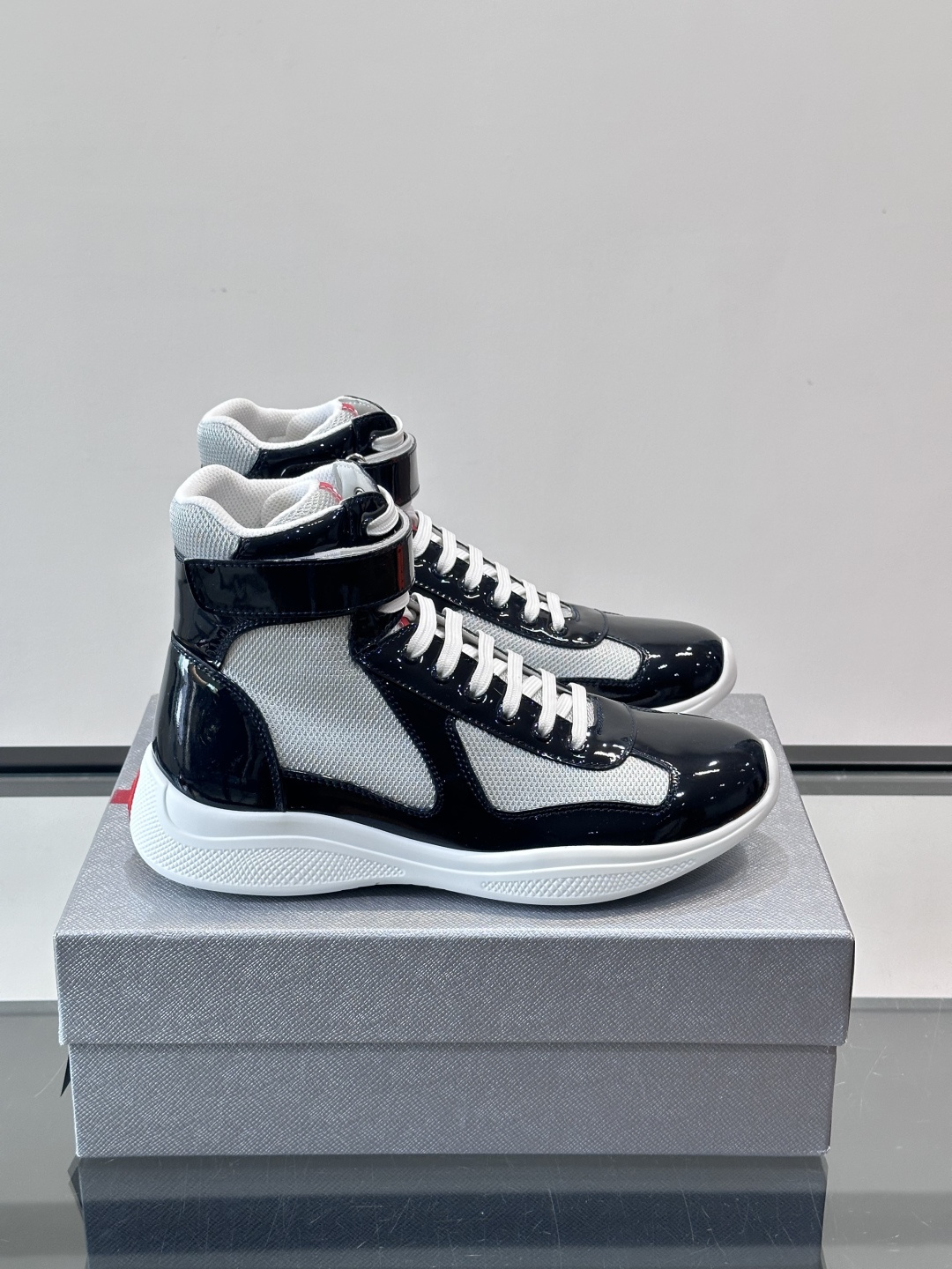 Prada 美洲杯高帮运动鞋​​✨Prada美洲杯系列运动鞋，漆皮+网面拼接，光泽感与透气性兼具。高帮设