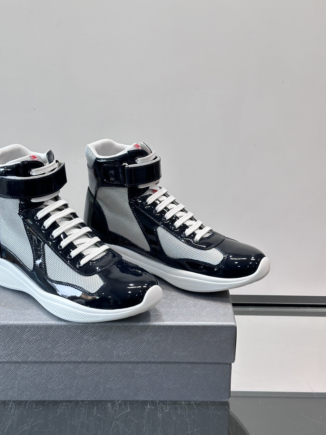 Prada 美洲杯高帮运动鞋​​✨Prada美洲杯系列运动鞋，漆皮+网面拼接，光泽感与透气性兼具。高帮设