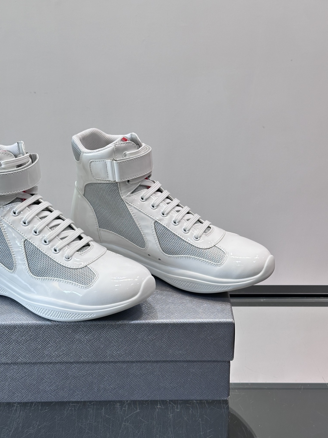 Prada 美洲杯高帮运动鞋​​✨Prada美洲杯系列运动鞋，漆皮+网面拼接，光泽感与透气性兼具。高帮设