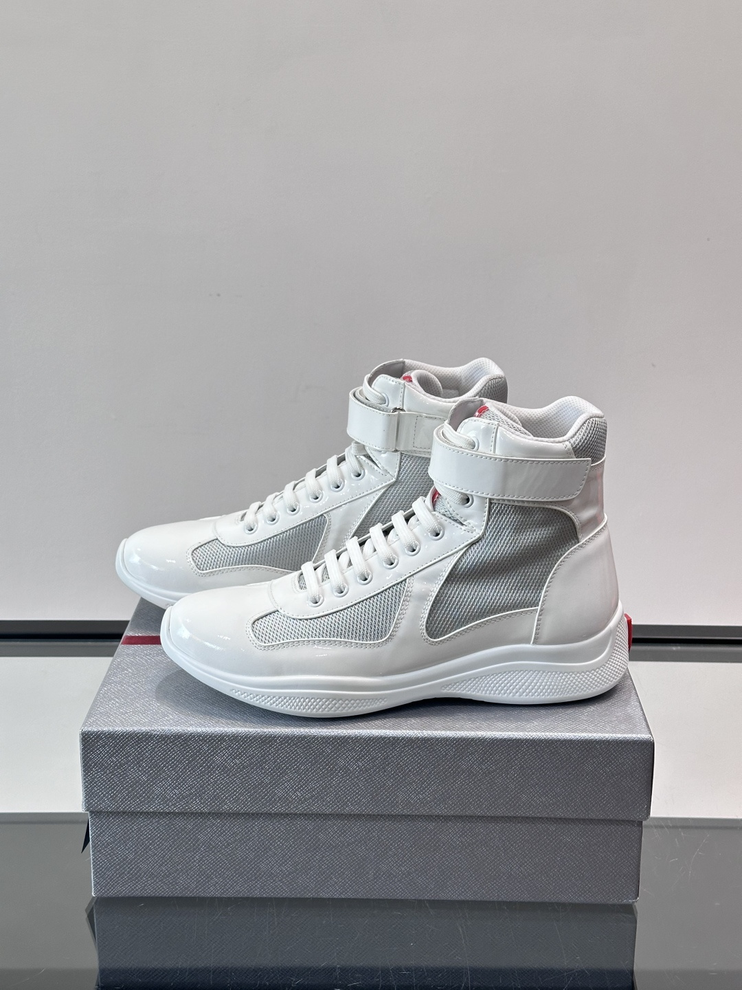 Prada 美洲杯高帮运动鞋​​✨Prada美洲杯系列运动鞋，漆皮+网面拼接，光泽感与透气性兼具。高帮设