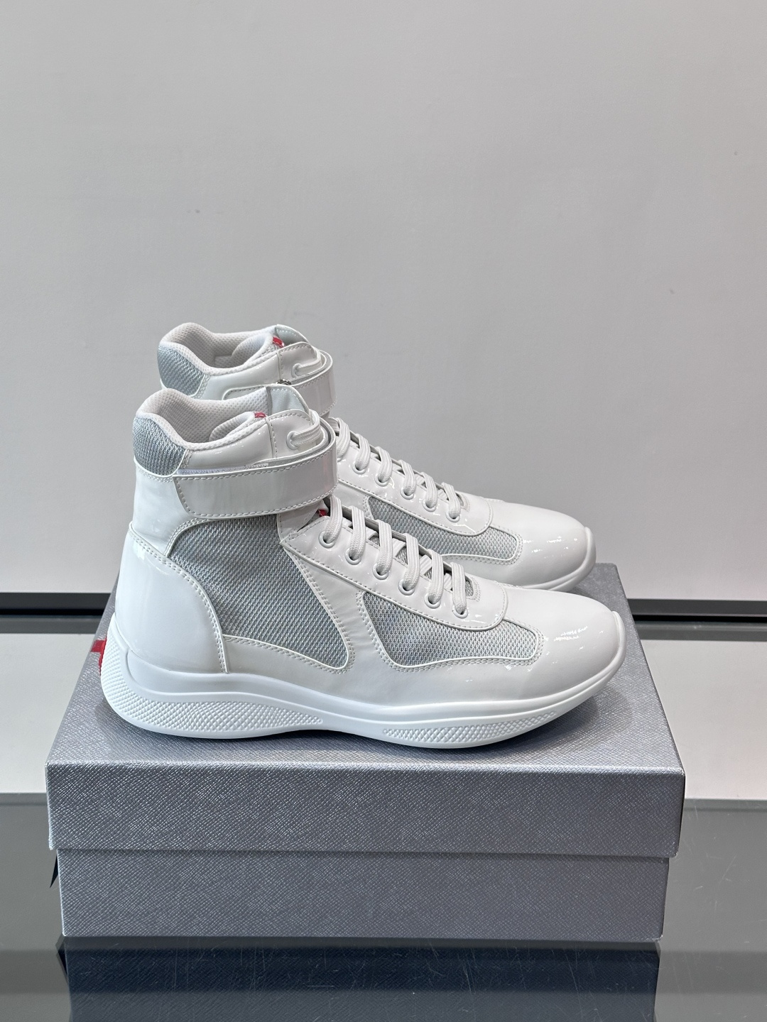 Prada 美洲杯高帮运动鞋​​✨Prada美洲杯系列运动鞋，漆皮+网面拼接，光泽感与透气性兼具。高帮设