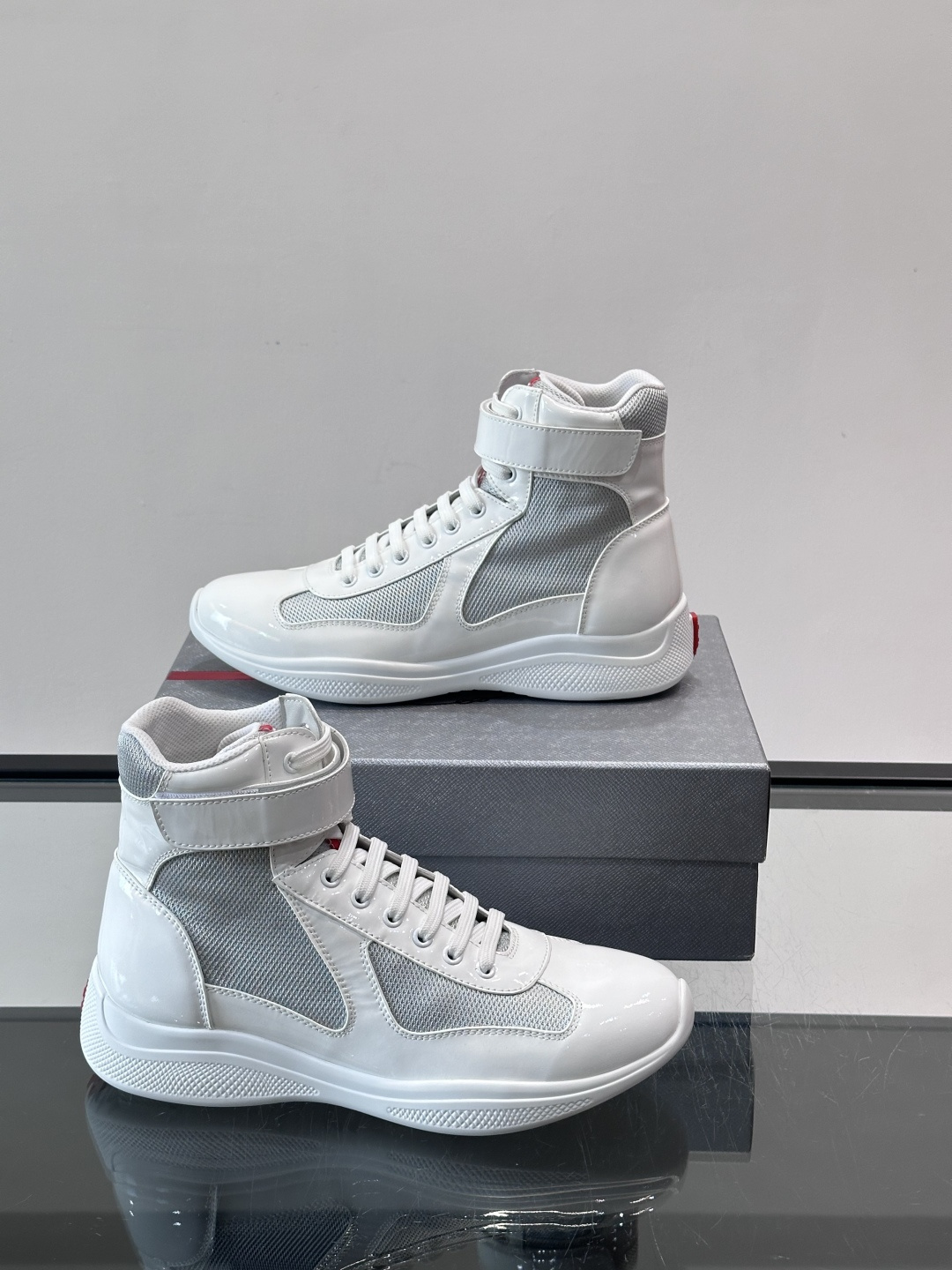 Prada 美洲杯高帮运动鞋​​✨Prada美洲杯系列运动鞋，漆皮+网面拼接，光泽感与透气性兼具。高帮设