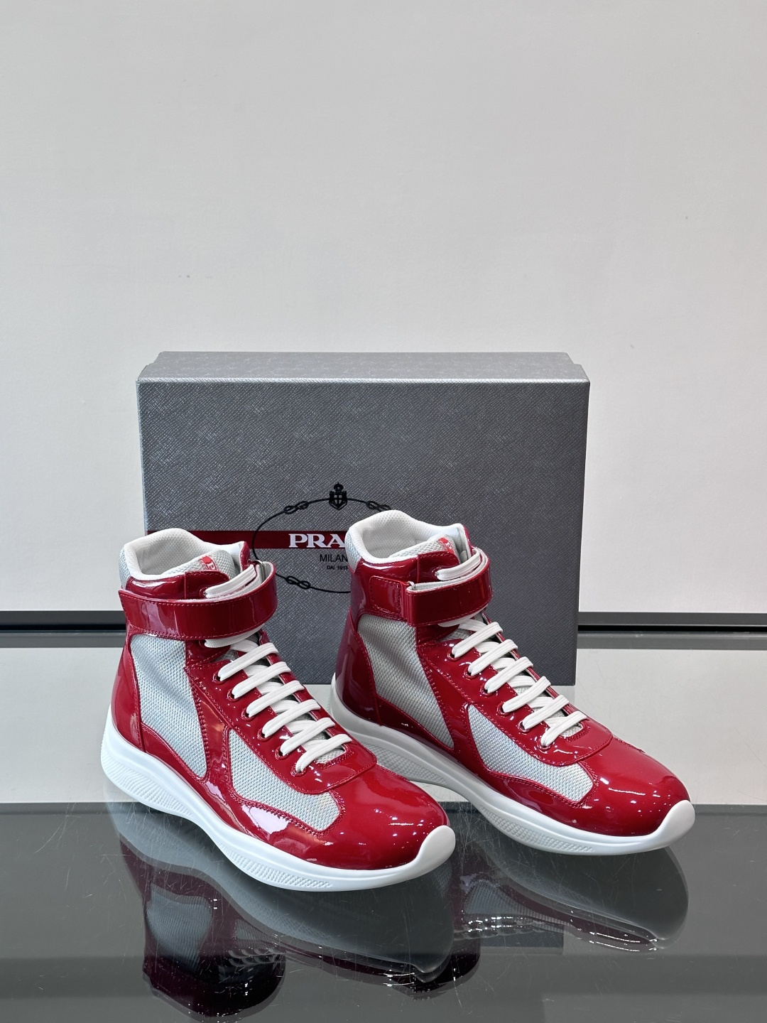 Prada 美洲杯高帮运动鞋​​✨Prada美洲杯系列运动鞋，漆皮+网面拼接，光泽感与透气性兼具。高帮设