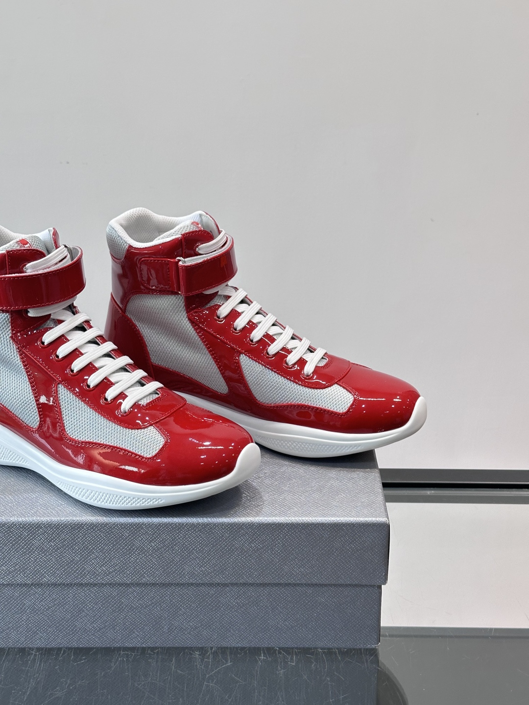 Prada 美洲杯高帮运动鞋​​✨Prada美洲杯系列运动鞋，漆皮+网面拼接，光泽感与透气性兼具。高帮设