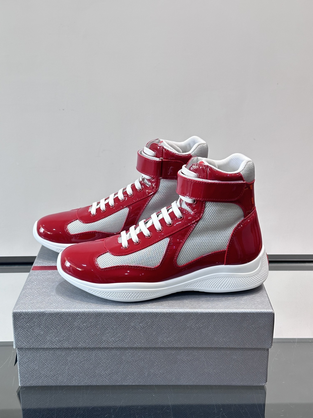 Prada 美洲杯高帮运动鞋​​✨Prada美洲杯系列运动鞋，漆皮+网面拼接，光泽感与透气性兼具。高帮设