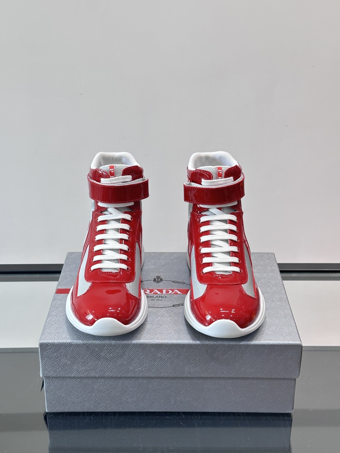 Prada 美洲杯高帮运动鞋​​✨Prada美洲杯系列运动鞋，漆皮+网面拼接，光泽感与透气性兼具。高帮设