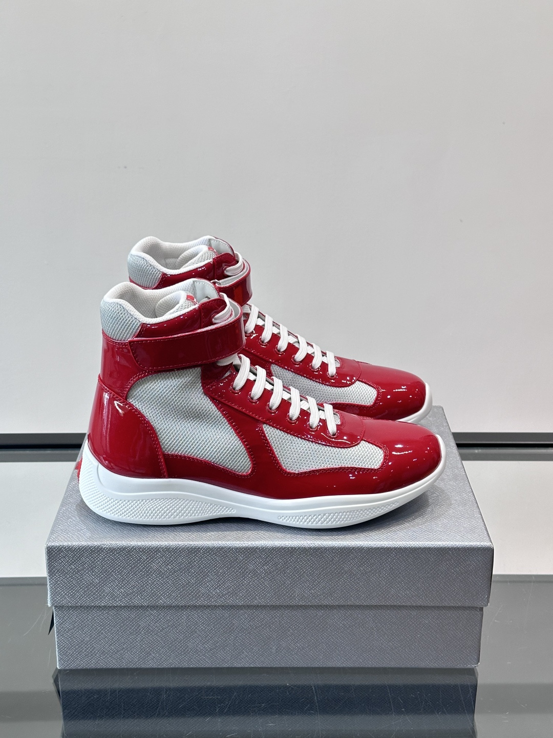 Prada 美洲杯高帮运动鞋​​✨Prada美洲杯系列运动鞋，漆皮+网面拼接，光泽感与透气性兼具。高帮设