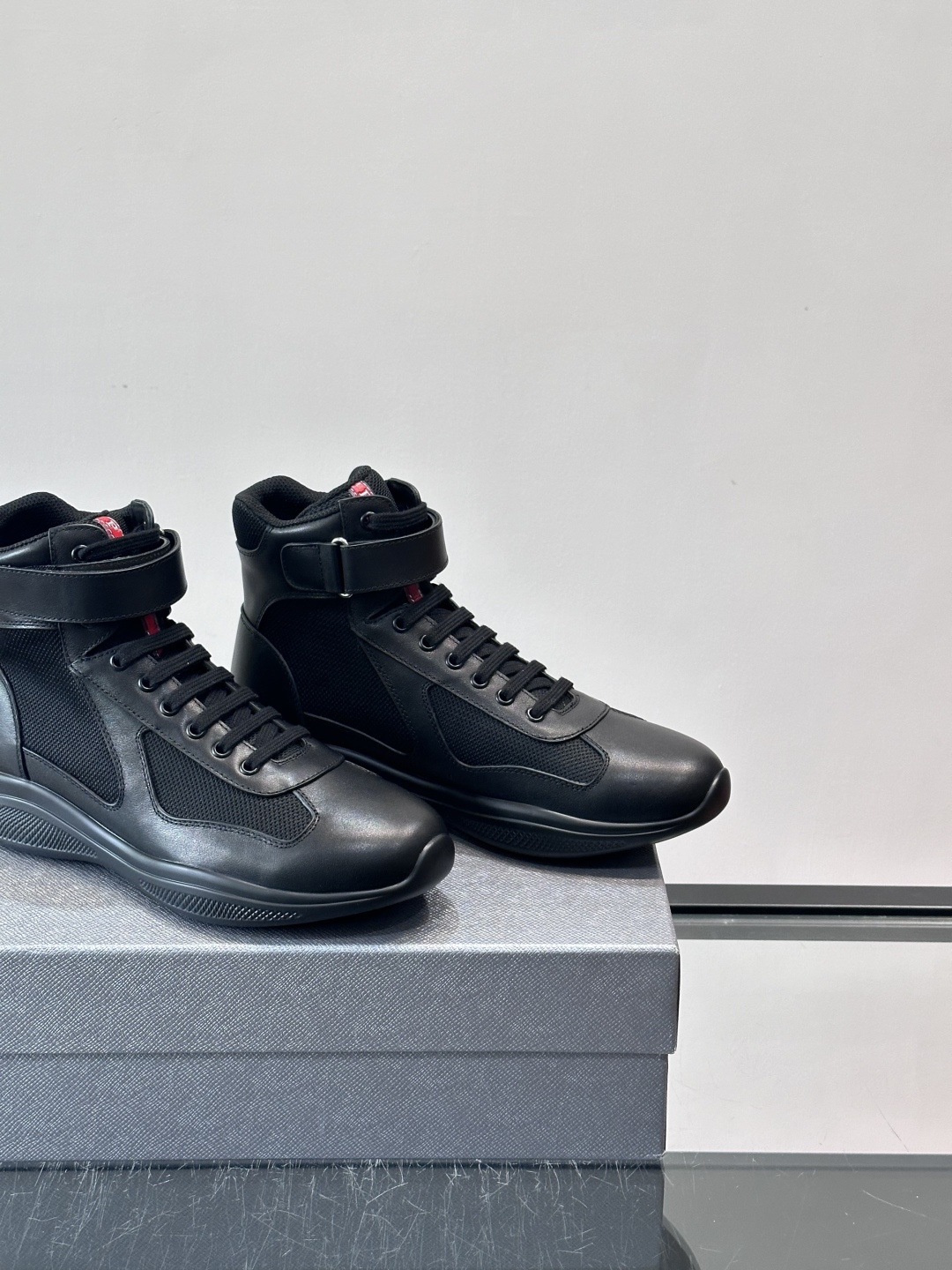 Prada 美洲杯高帮运动鞋​​✨Prada美洲杯系列运动鞋，漆皮+网面拼接，光泽感与透气性兼具。高帮设