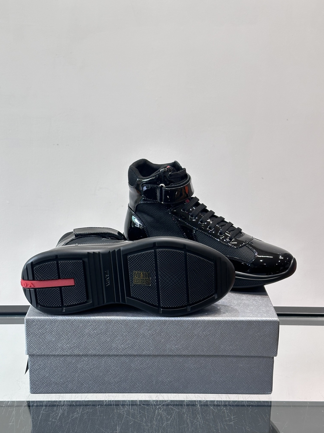 Prada 美洲杯高帮运动鞋​​✨Prada美洲杯系列运动鞋，漆皮+网面拼接，光泽感与透气性兼具。高帮设