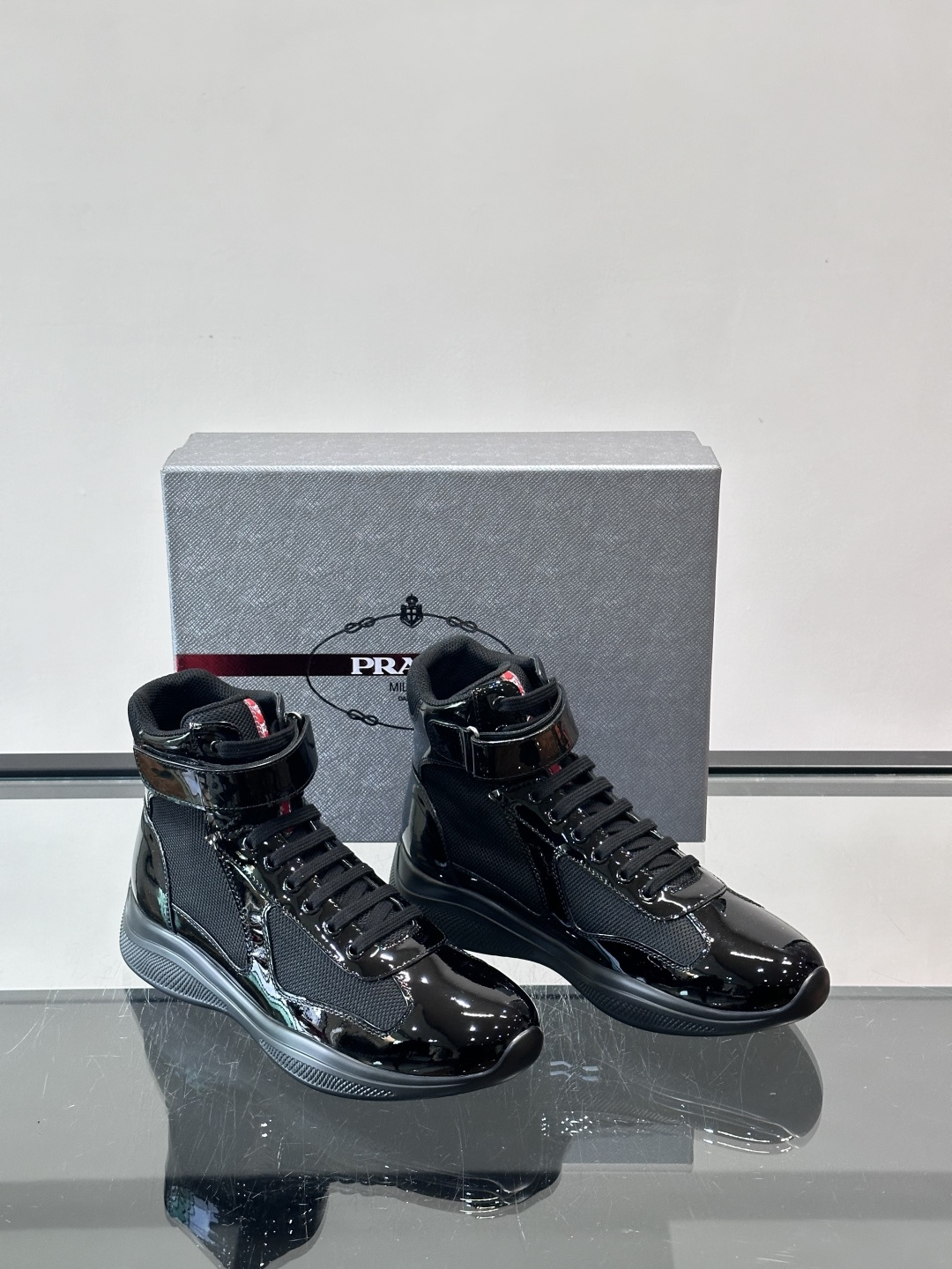 Prada 美洲杯高帮运动鞋​​✨Prada美洲杯系列运动鞋，漆皮+网面拼接，光泽感与透气性兼具。高帮设