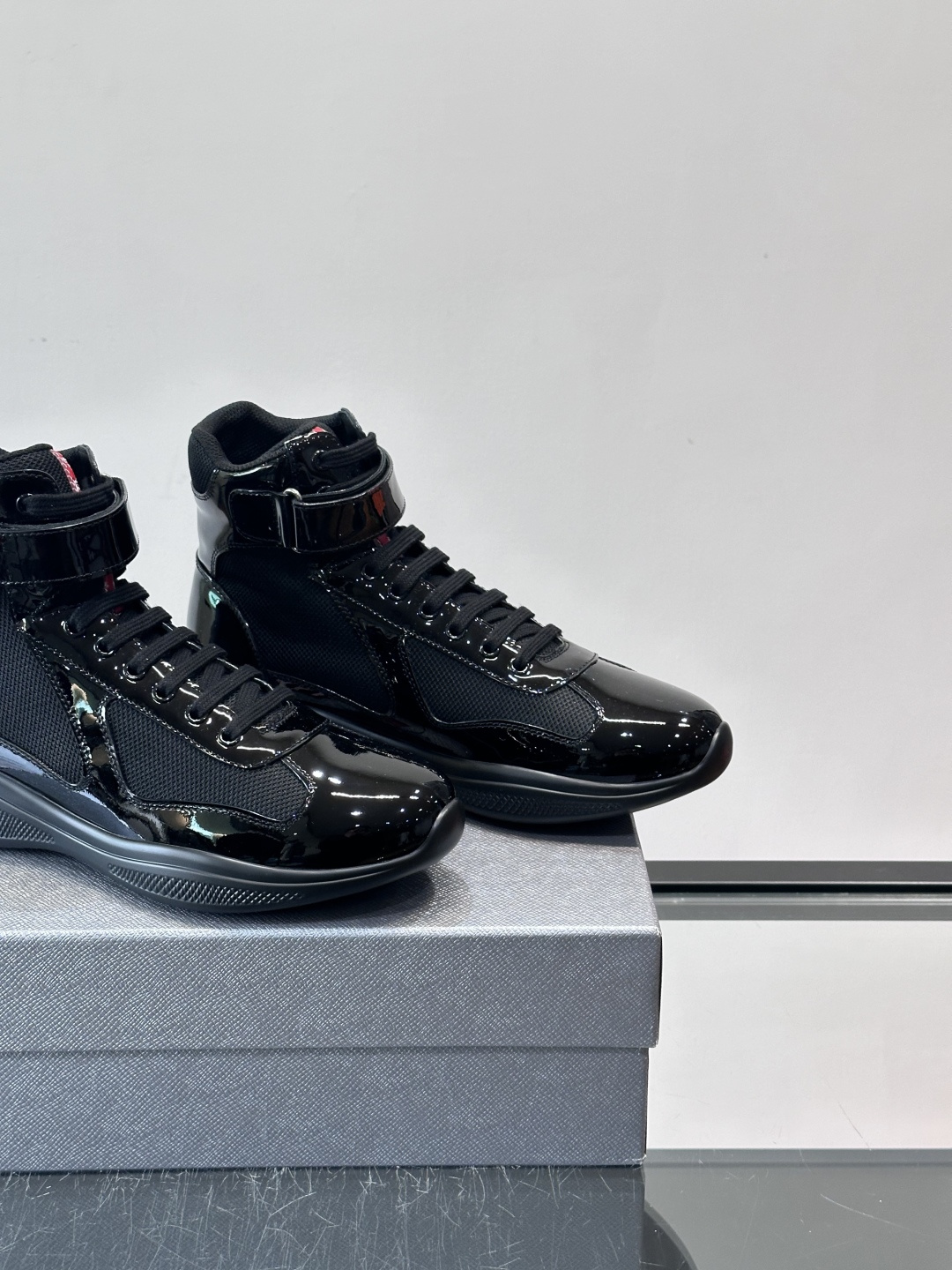 Prada 美洲杯高帮运动鞋​​✨Prada美洲杯系列运动鞋，漆皮+网面拼接，光泽感与透气性兼具。高帮设