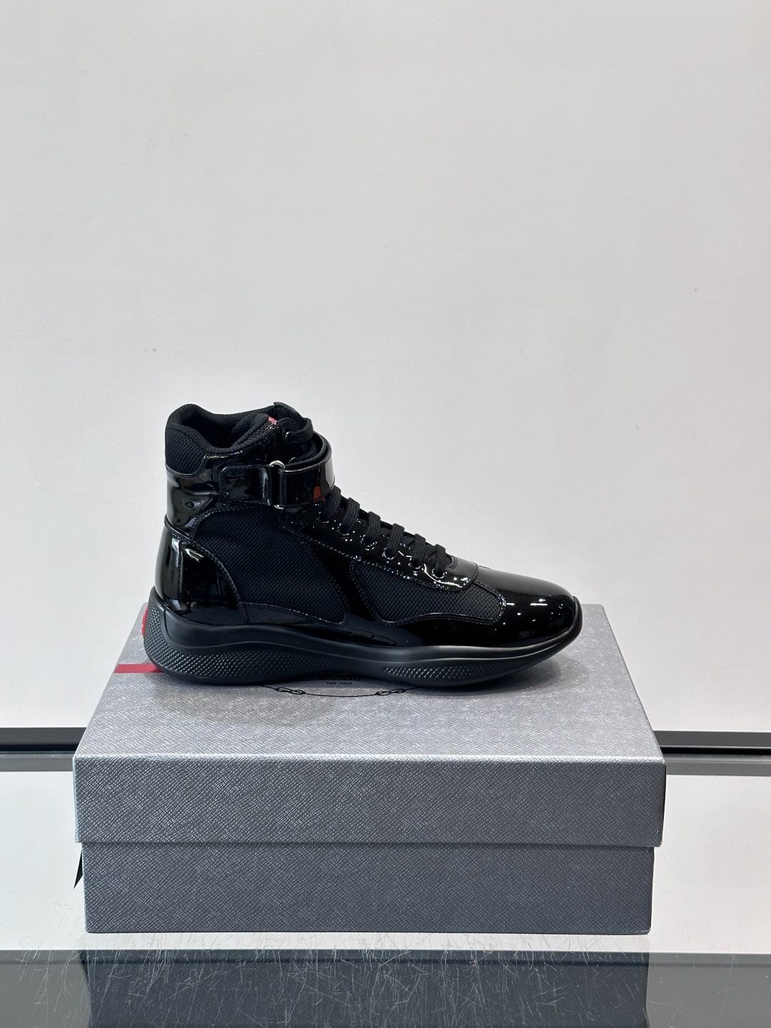 Prada 美洲杯高帮运动鞋​​✨Prada美洲杯系列运动鞋，漆皮+网面拼接，光泽感与透气性兼具。高帮设