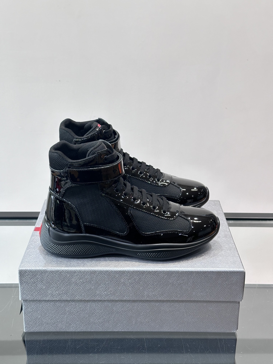 Prada 美洲杯高帮运动鞋​​✨Prada美洲杯系列运动鞋，漆皮+网面拼接，光泽感与透气性兼具。高帮设