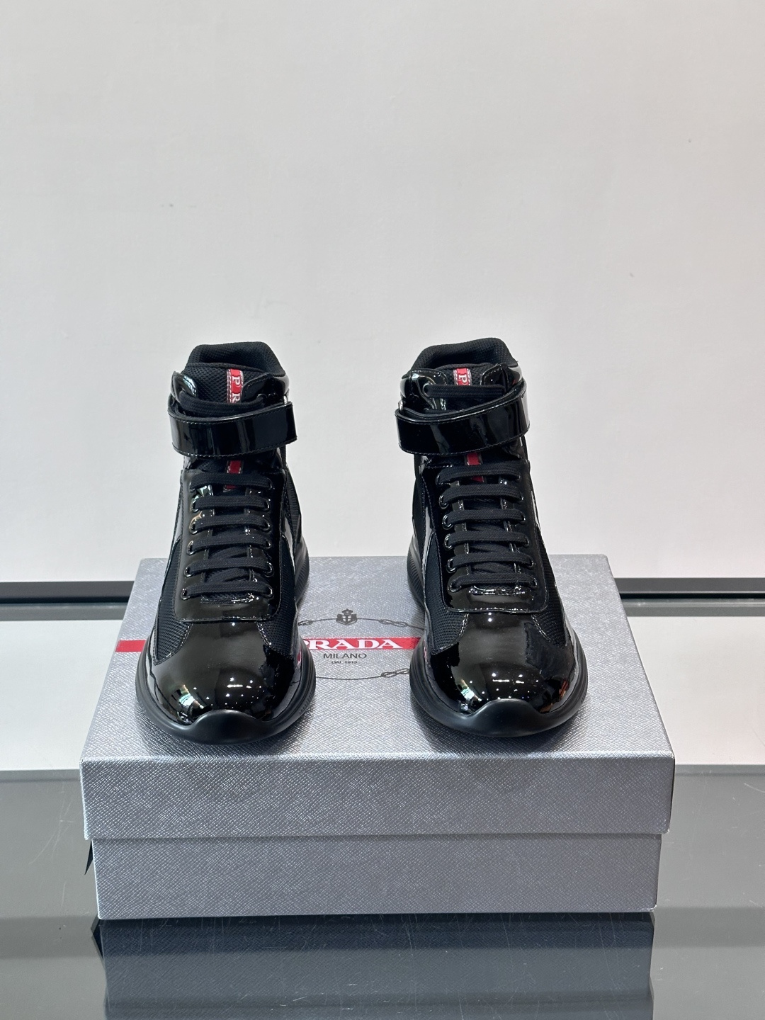 Prada 美洲杯高帮运动鞋​​✨Prada美洲杯系列运动鞋，漆皮+网面拼接，光泽感与透气性兼具。高帮设