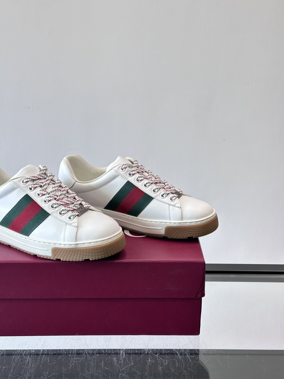Gucci经典的复古运动鞋，采用麂皮鞋面，搭配品牌标志性的红绿织带，鞋带为红白格纹设计，鞋底为橡胶➕防滑