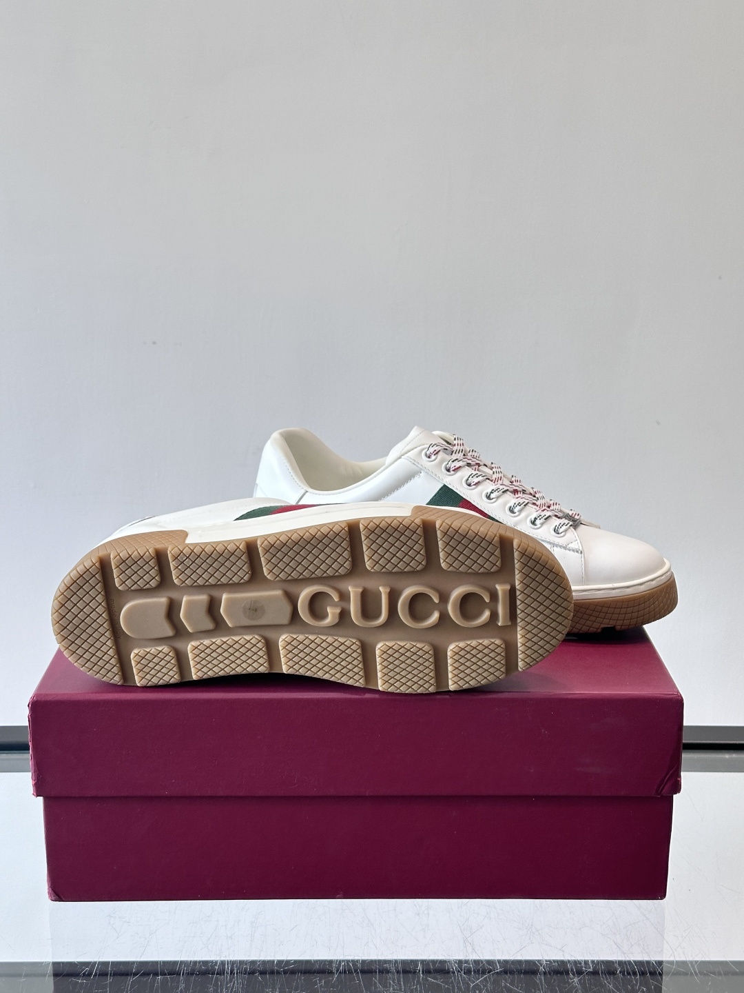 Gucci经典的复古运动鞋，采用麂皮鞋面，搭配品牌标志性的红绿织带，鞋带为红白格纹设计，鞋底为橡胶➕防滑