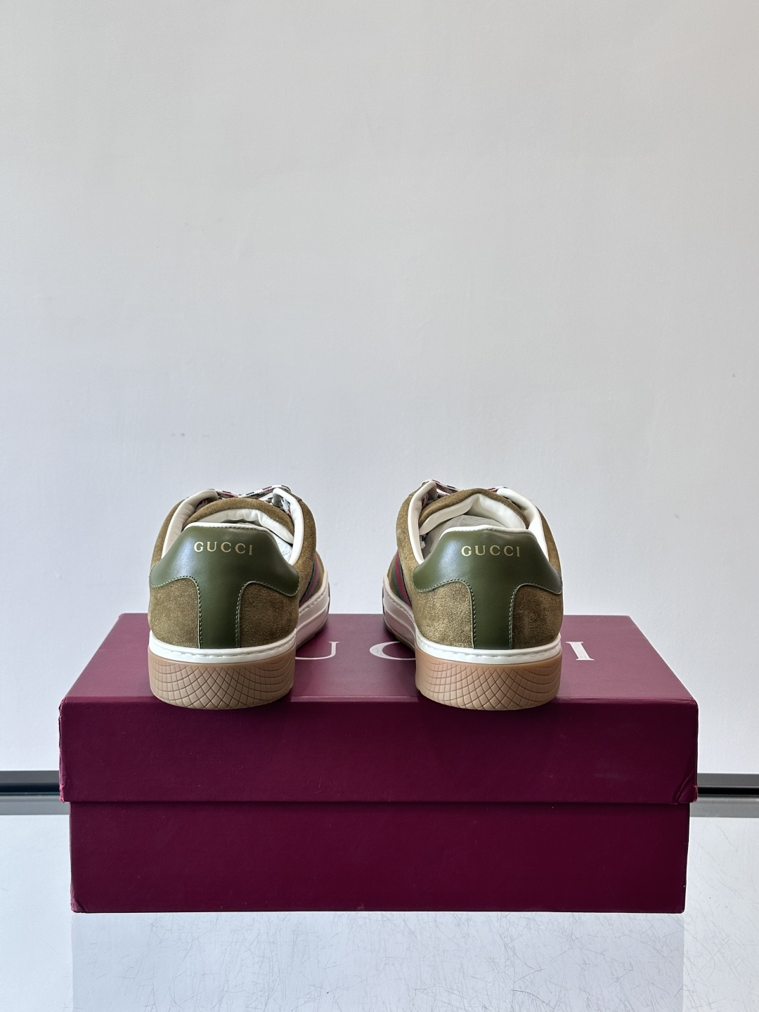Gucci经典的复古运动鞋，采用麂皮鞋面，搭配品牌标志性的红绿织带，鞋带为红白格纹设计，鞋底为橡胶➕防滑