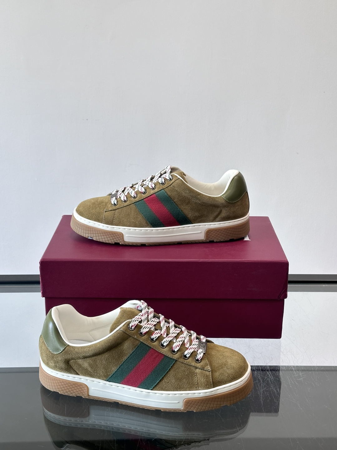 Gucci经典的复古运动鞋，采用麂皮鞋面，搭配品牌标志性的红绿织带，鞋带为红白格纹设计，鞋底为橡胶➕防滑